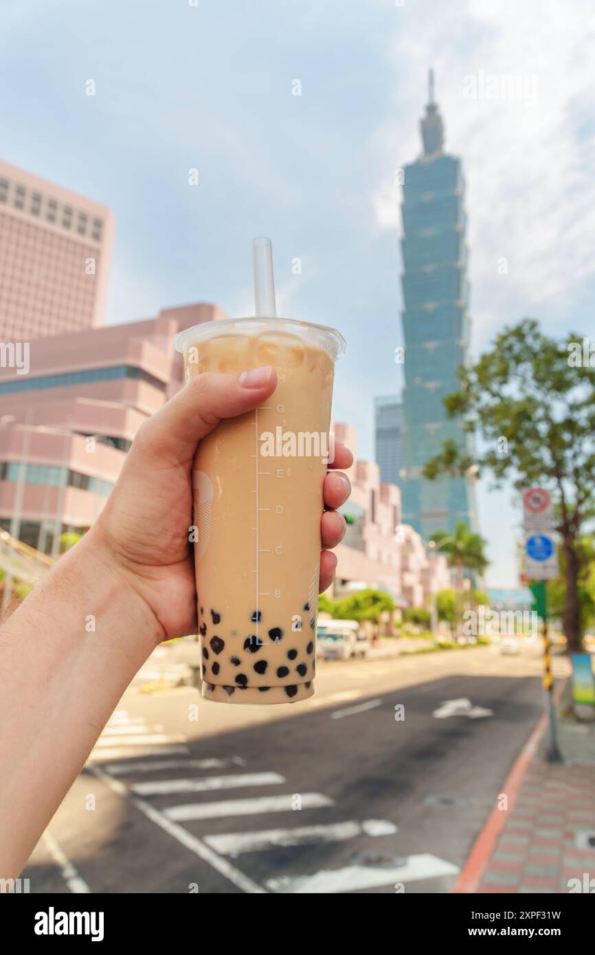 Mano maschile che regge il tradizionale tè taiwanese al latte bollente Foto Stock
