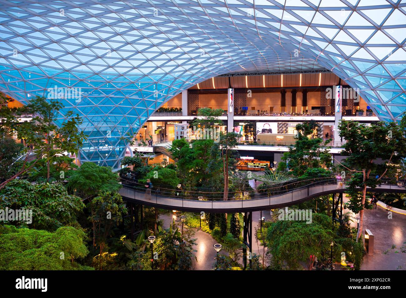 Enorme cupola di vetro e passaggio sopraelevato sopra il giardino interno presso l'Orchard dell'Aeroporto Internazionale Hamad di Doha Foto Stock