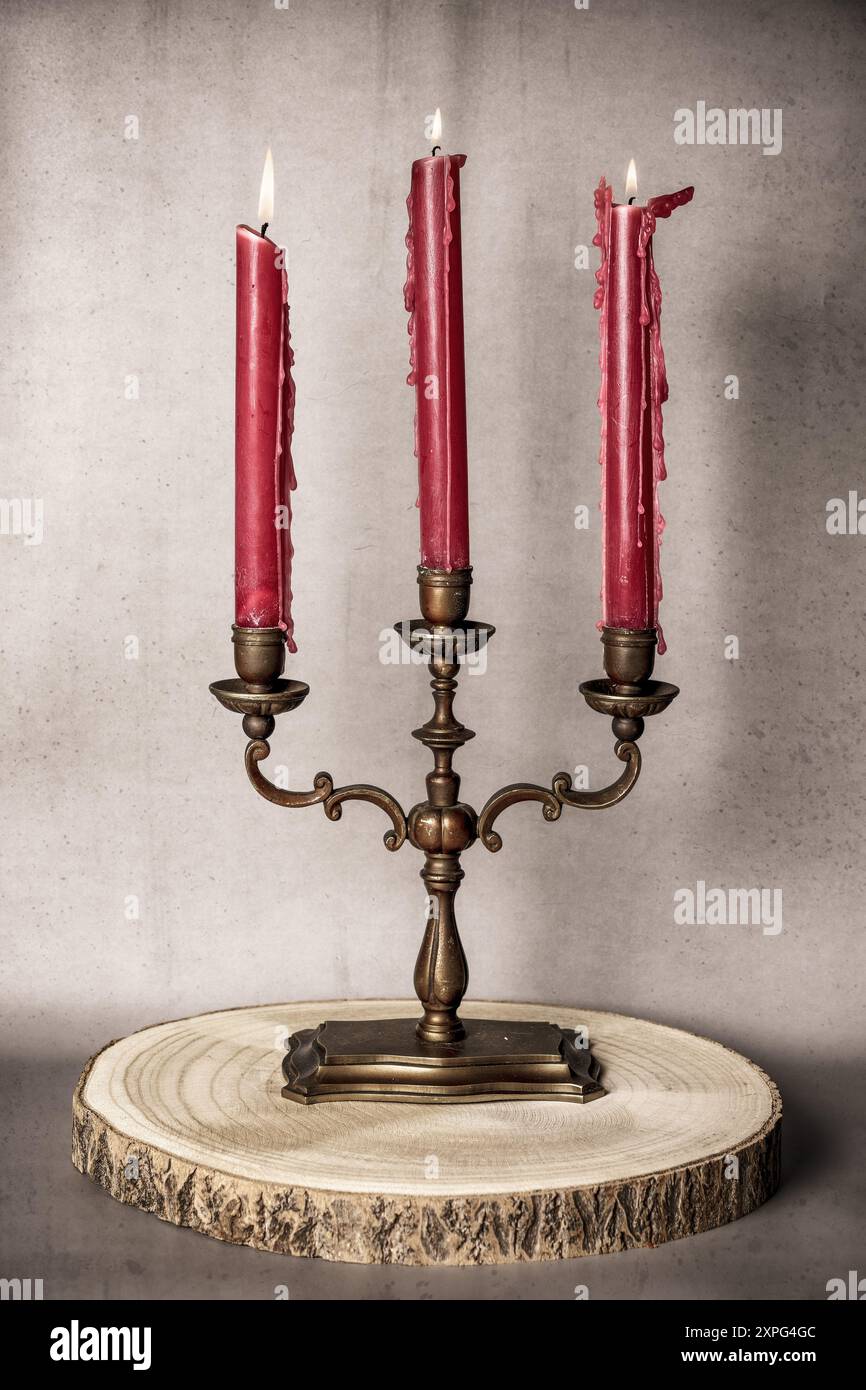 Candela accesa con candelabro rosso Foto Stock