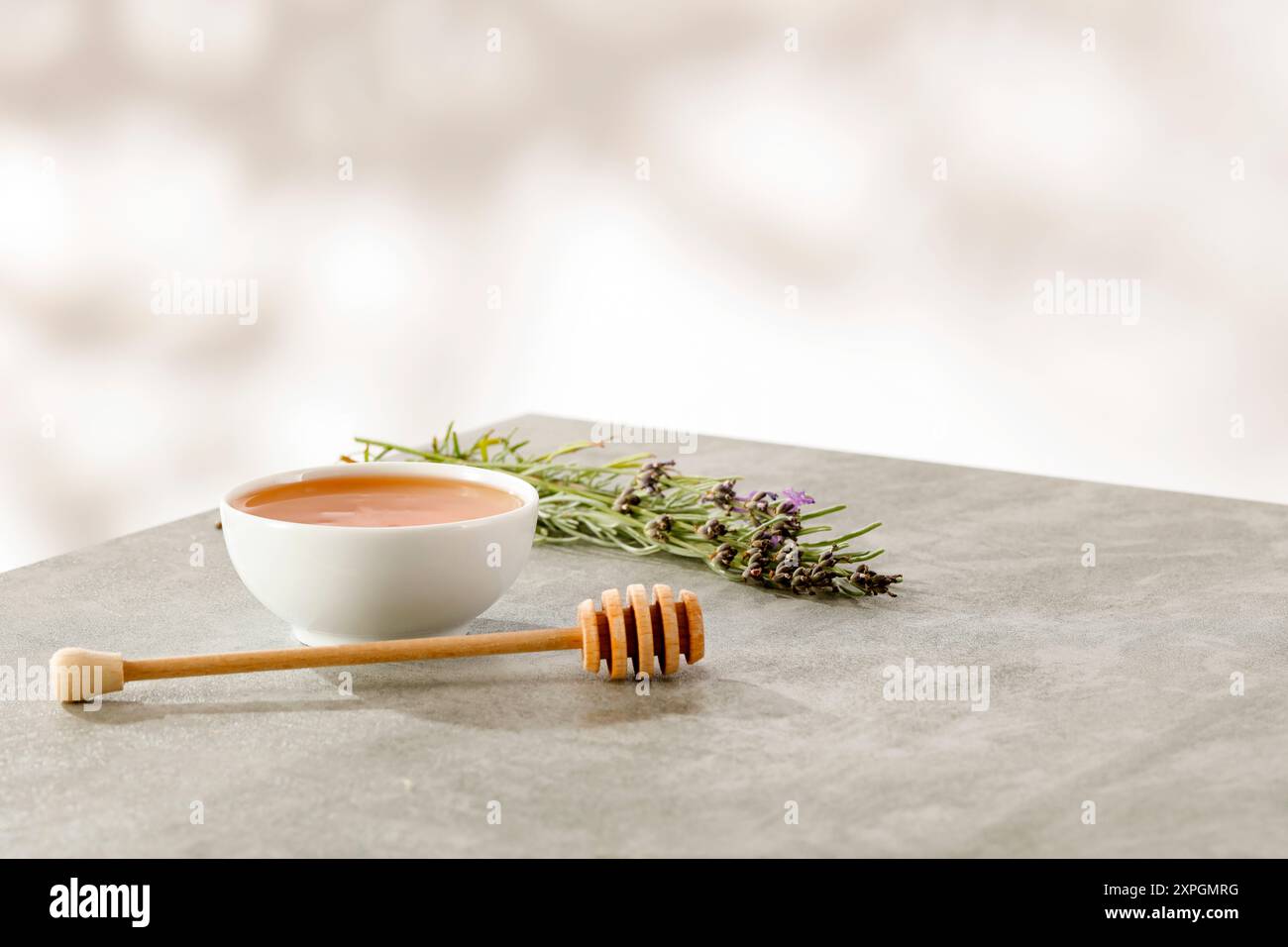 Ciotola di miele sul piano del tavolo con sfondo naturale sfocato e posto per i prodotti di montaggio. Foto Stock
