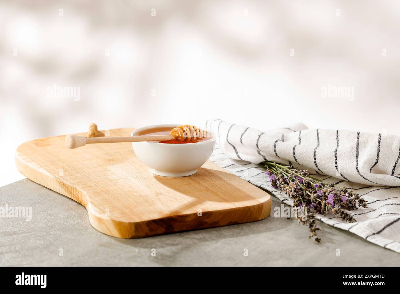 Ciotola di miele sul piano del tavolo con sfondo naturale sfocato e posto per i prodotti di montaggio. Foto Stock
