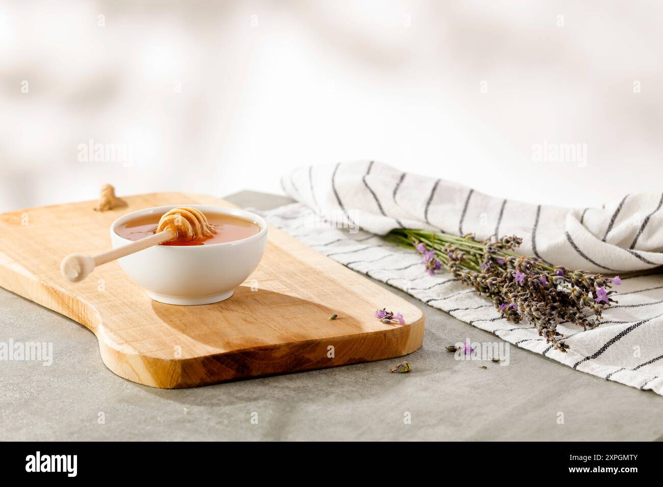 Ciotola di miele sul piano del tavolo con sfondo naturale sfocato e posto per i prodotti di montaggio. Foto Stock
