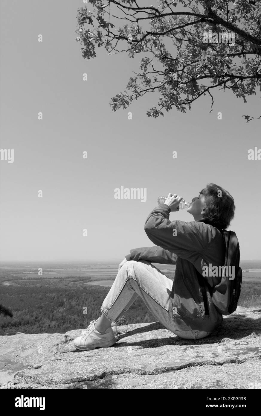 Donna caucasica da 50 a 55 anni che riposa e beve acqua in bottiglia in un punto panoramico del Petit Jean State Park vicino a Morrilton, Arkansas. STATI UNITI. Foto Stock