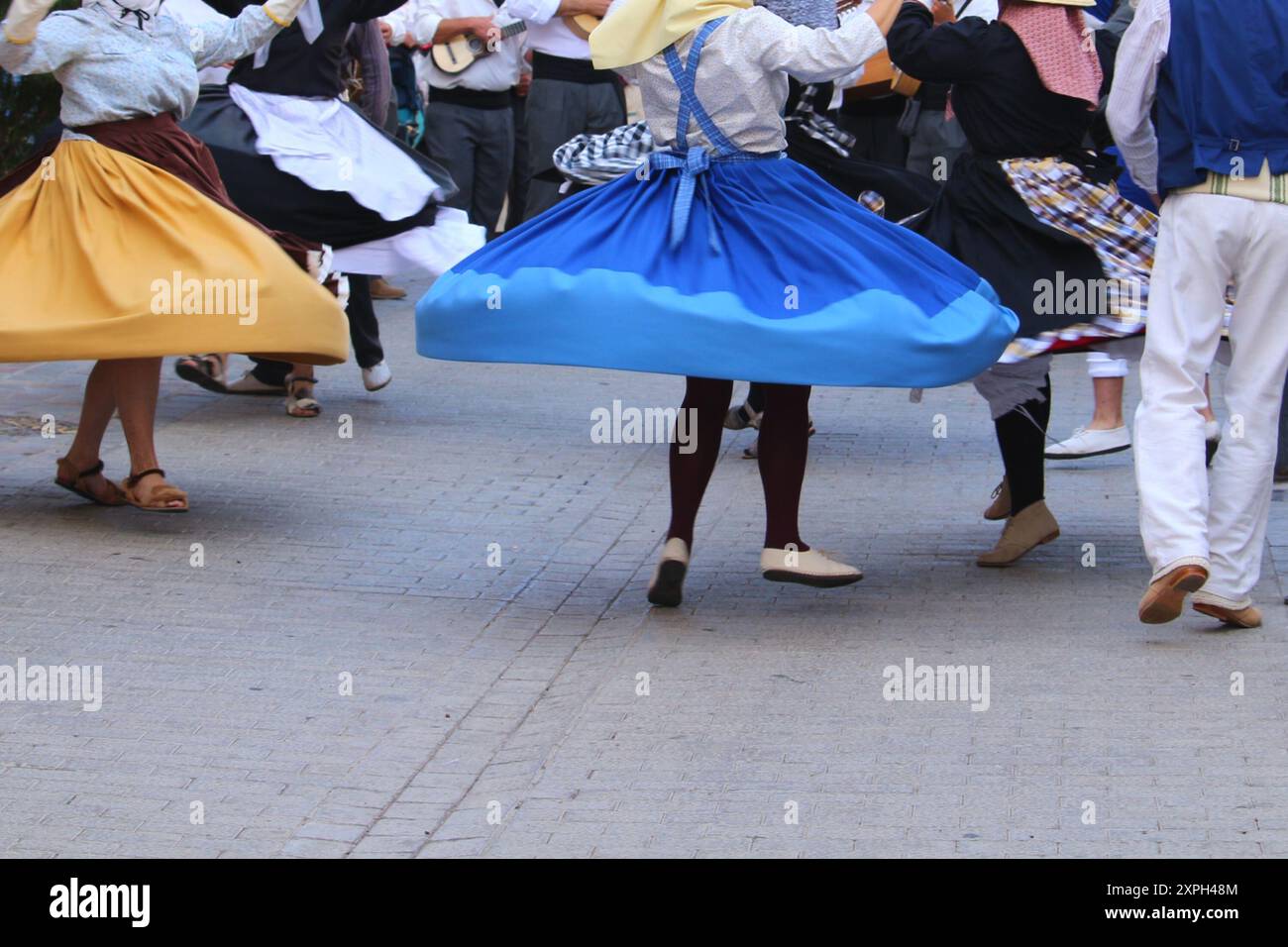 Gonne oscillanti di ballerini locali in abiti tradizionali delle Canarie in un festival pubblico, in movimento blur, la Gomera, Spagna Foto Stock
