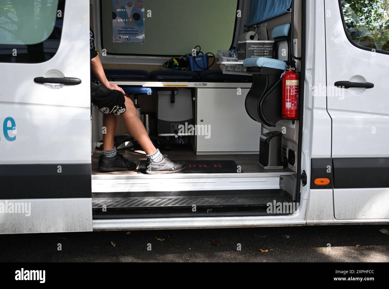 Mainz, Germania. 5 agosto 2024. Un senzatetto viene curato nell'unità medica mobile dell'Associazione per la povertà e la salute in Germania. I membri dell'associazione sono in giro a Magonza diversi giorni alla settimana, distribuendo acqua, crema solare e copricapo ai senzatetto. Credito: Arne Dedert/dpa/Alamy Live News Foto Stock