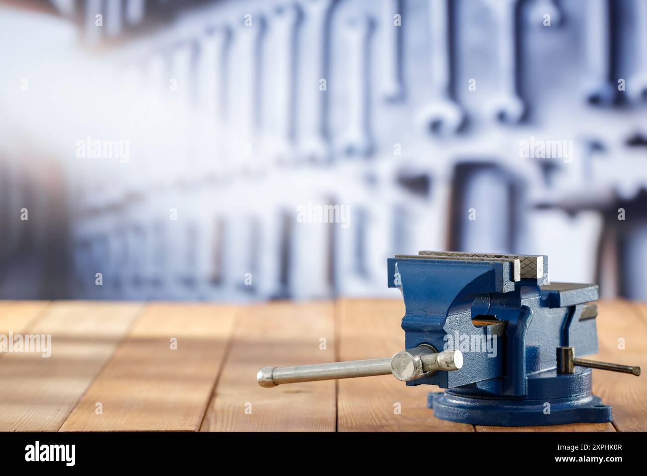 Utensili da falegname e morsa per fabbro su tavolo in legno su sfondo sfocato dell'officina, montaggio su espositore Foto Stock