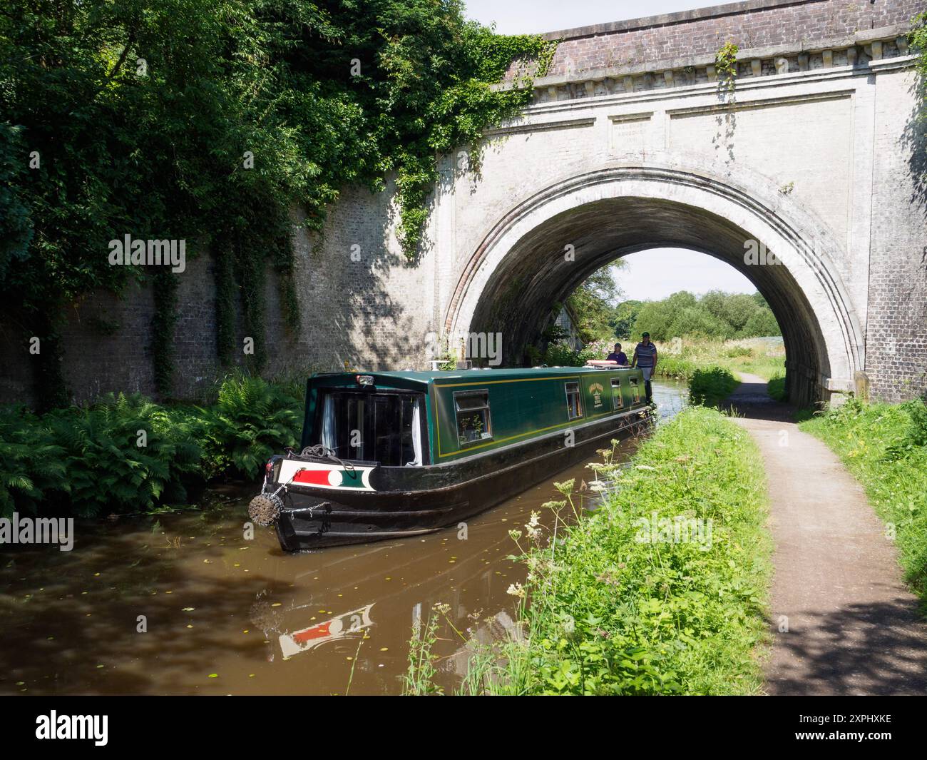 Una stretta barca passa sotto l'Hazlehurst Aqeduct sul canale di Caldon Foto Stock