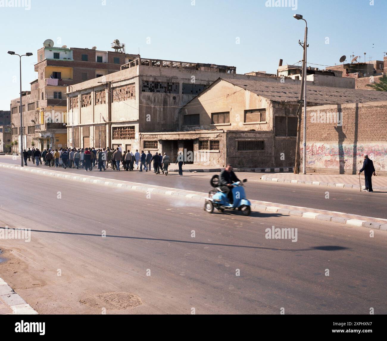 Una solenne processione funebre si svolge lungo il canale di Mahmoudiya ad Alessandria, in Egitto, nel novembre 2006. Lo sfondo urbano e i lutti riuniti mettono in risalto i costumi tradizionali della città e il sostegno comune. Foto Stock