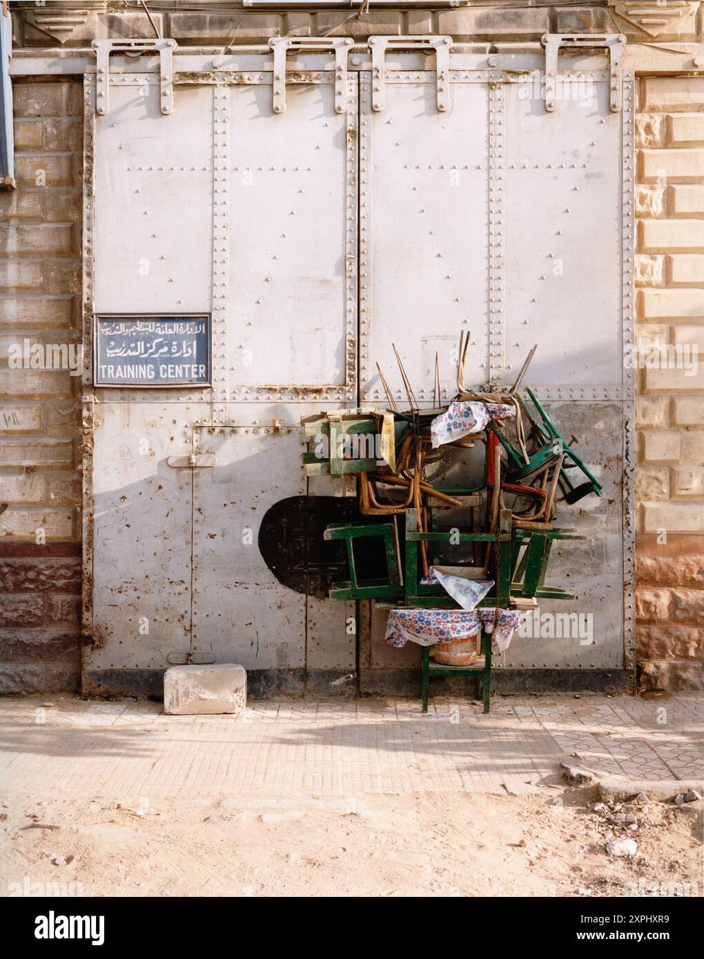 Sedie organizzate impilate ordinatamente vicino a un centro di formazione industriale nel porto occidentale di Alessandria. Catturata nel 2006, questa immagine riflette la semplicità della vita quotidiana dei porti. Foto Stock