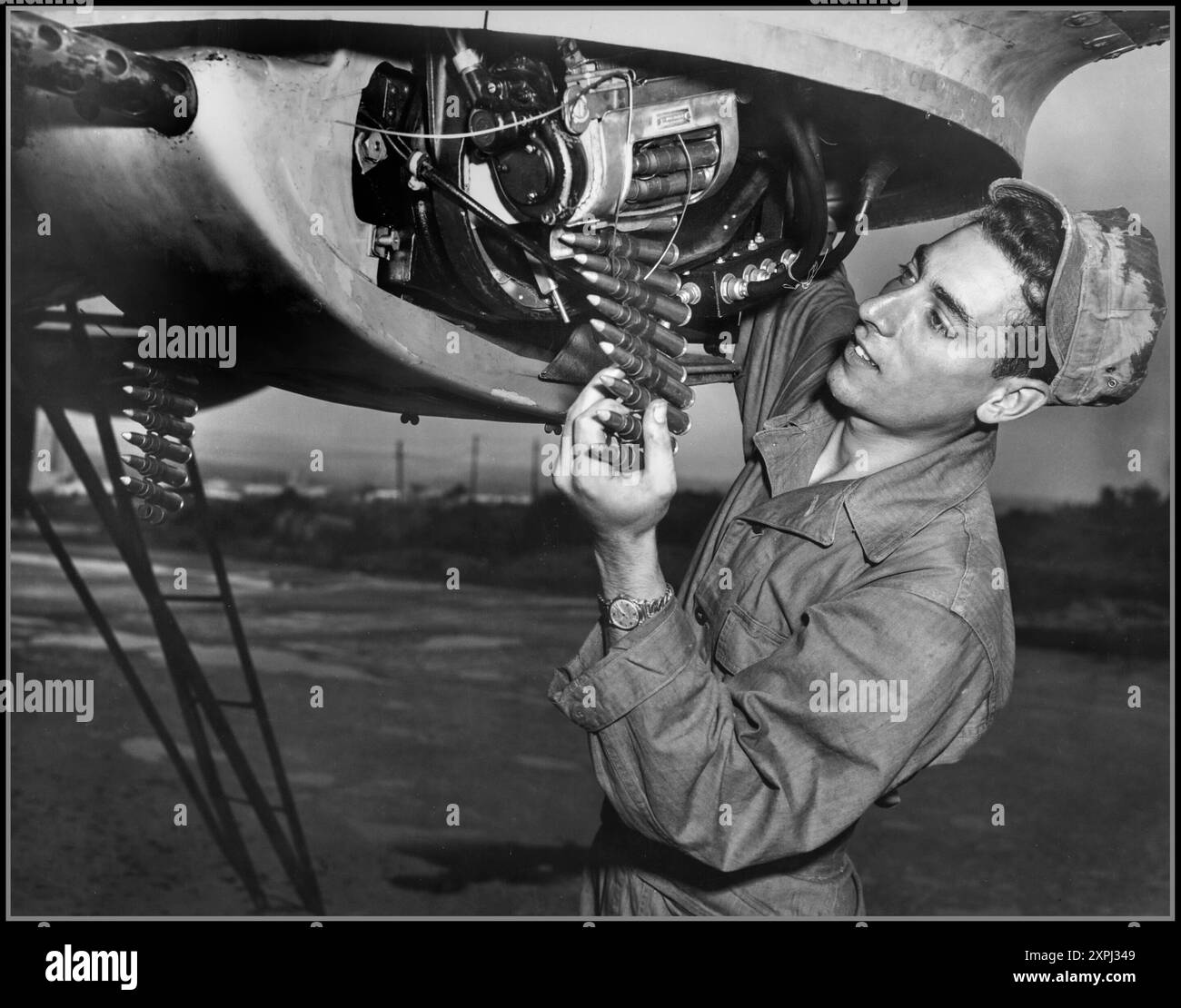 GUERRA COREANA PROPAGANDA USAF 1952 HQ., 20TH AIR FORCE, OKINAWA --- mentre il tempo di decollo si avvicina, Airman Joseph Migliardi, 274 King St., Port Chester, N.Y., esegue un controllo all'ultimo minuto sull'apparato di controllo remoto delle sue mitragliatrici calibro .50. Un cannoniere "Superfort" del 19th Bomber Group del far East Air Forces Bomber Command di Okinawa, l'attenzione e la vigilanza dell'Airman Migliardi pagheranno in protezione attraverso i cieli coreani per i suoi B-29 e dieci compagni di equipaggio. È un veterano di 14 missioni di combattimento contro obiettivi di interdizione comunisti. Foto Stock