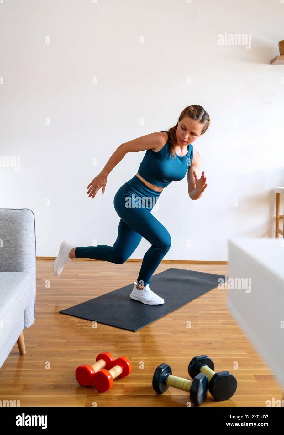 Giovane donna caucasica che indossa abbigliamento sportivo facendo esercizio fisico a casa. Stile di vita attivo e sano. Foto Stock
