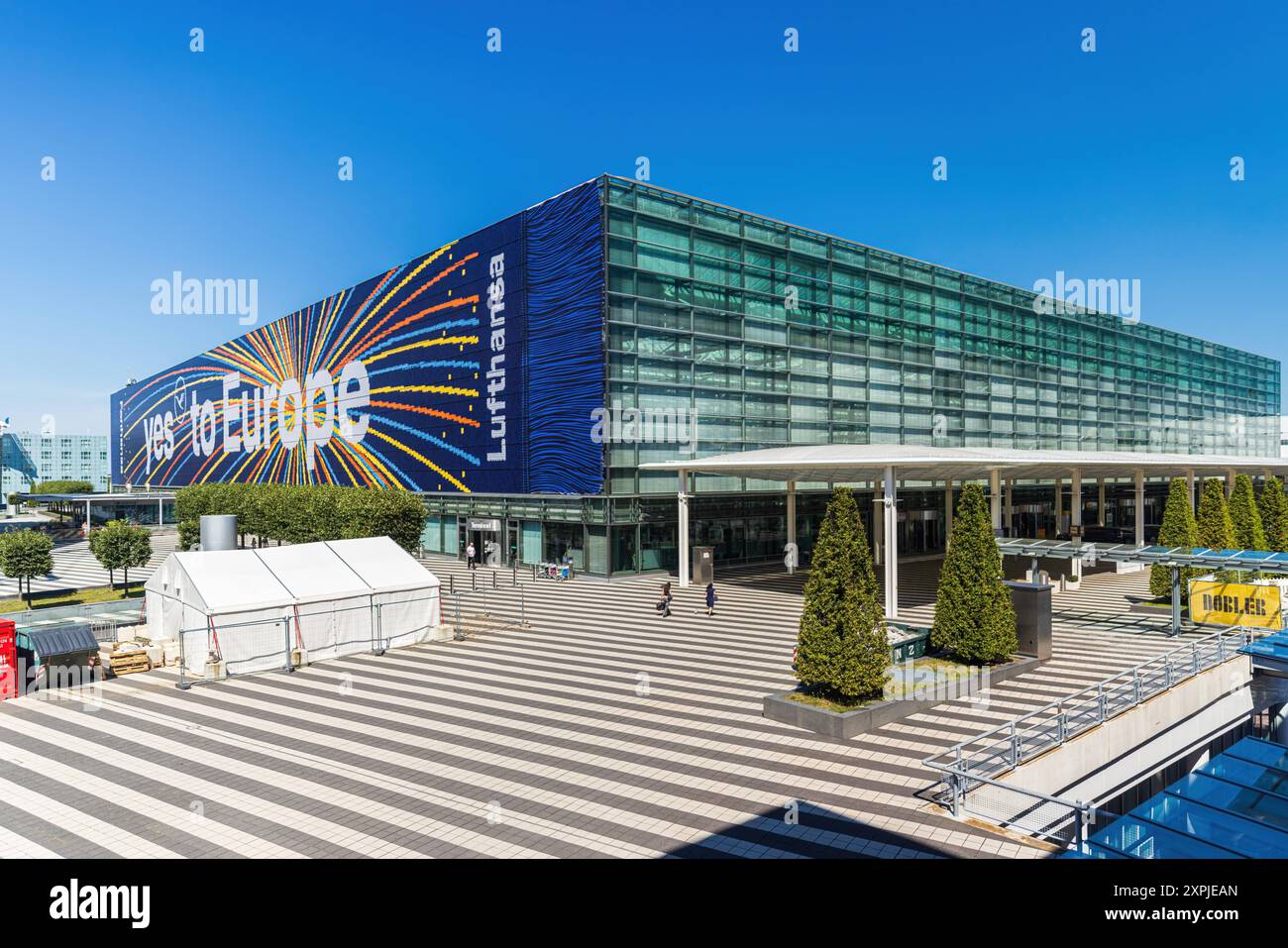 MONACO DI BAVIERA, GERMANIA - 6 AGOSTO 2024: Vista esterna dell'aeroporto di Monaco in una giornata di sole con cielo azzurro edificio principale del Terminal 2 con grande affermazione Lufthansa: Foto Stock