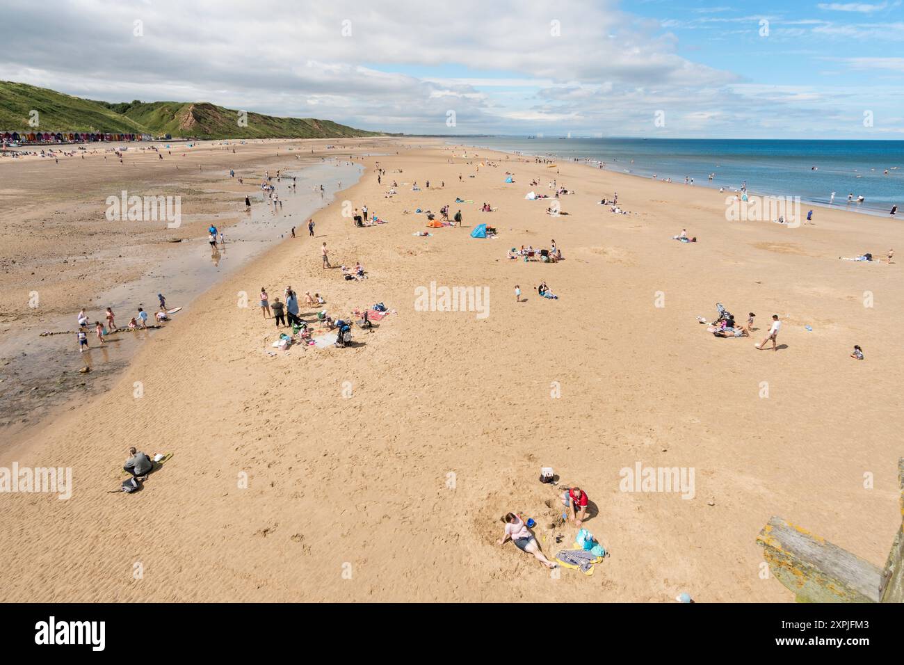 Persone che amano il sole estivo sulla spiaggia di Saltburn-by-the-Sea, Yorkshire, Inghilterra, Regno Unito Foto Stock
