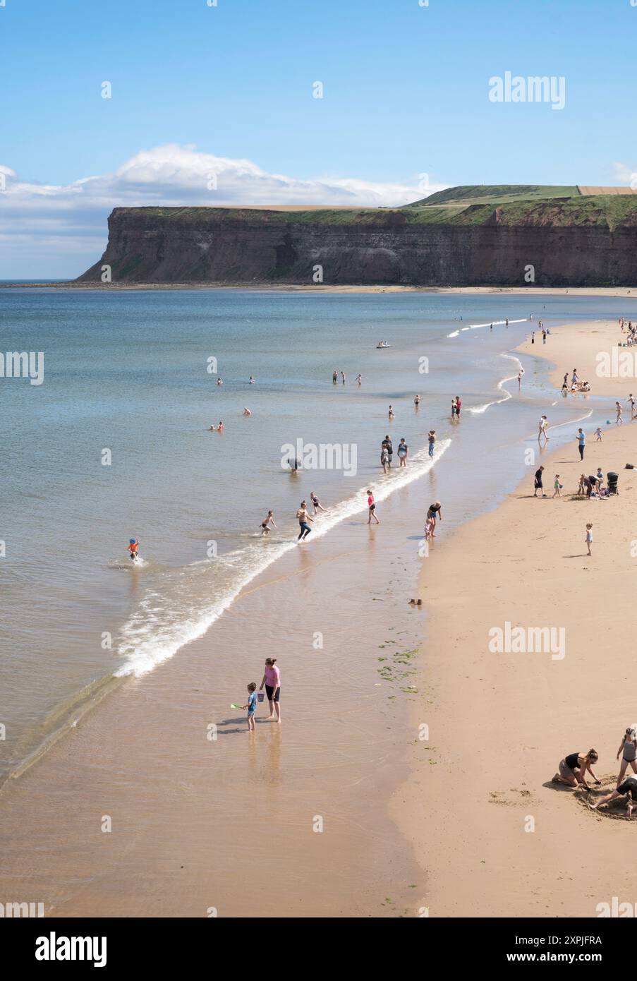 Persone che amano il sole estivo sulla spiaggia di Saltburn-by-the-Sea, Yorkshire, Inghilterra, Regno Unito Foto Stock