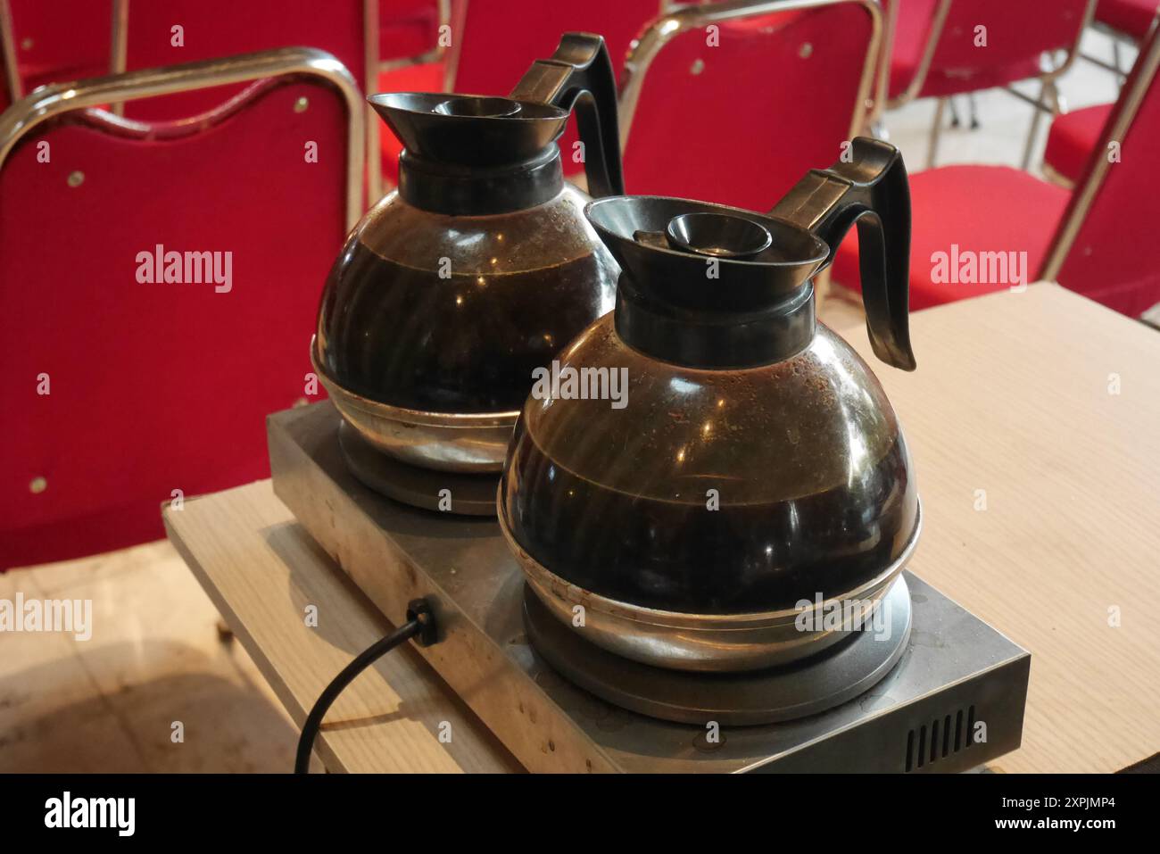 Due bollitori in vetro trasparente contenenti caffè nero sono montati su una stufa elettrica. Foto Stock