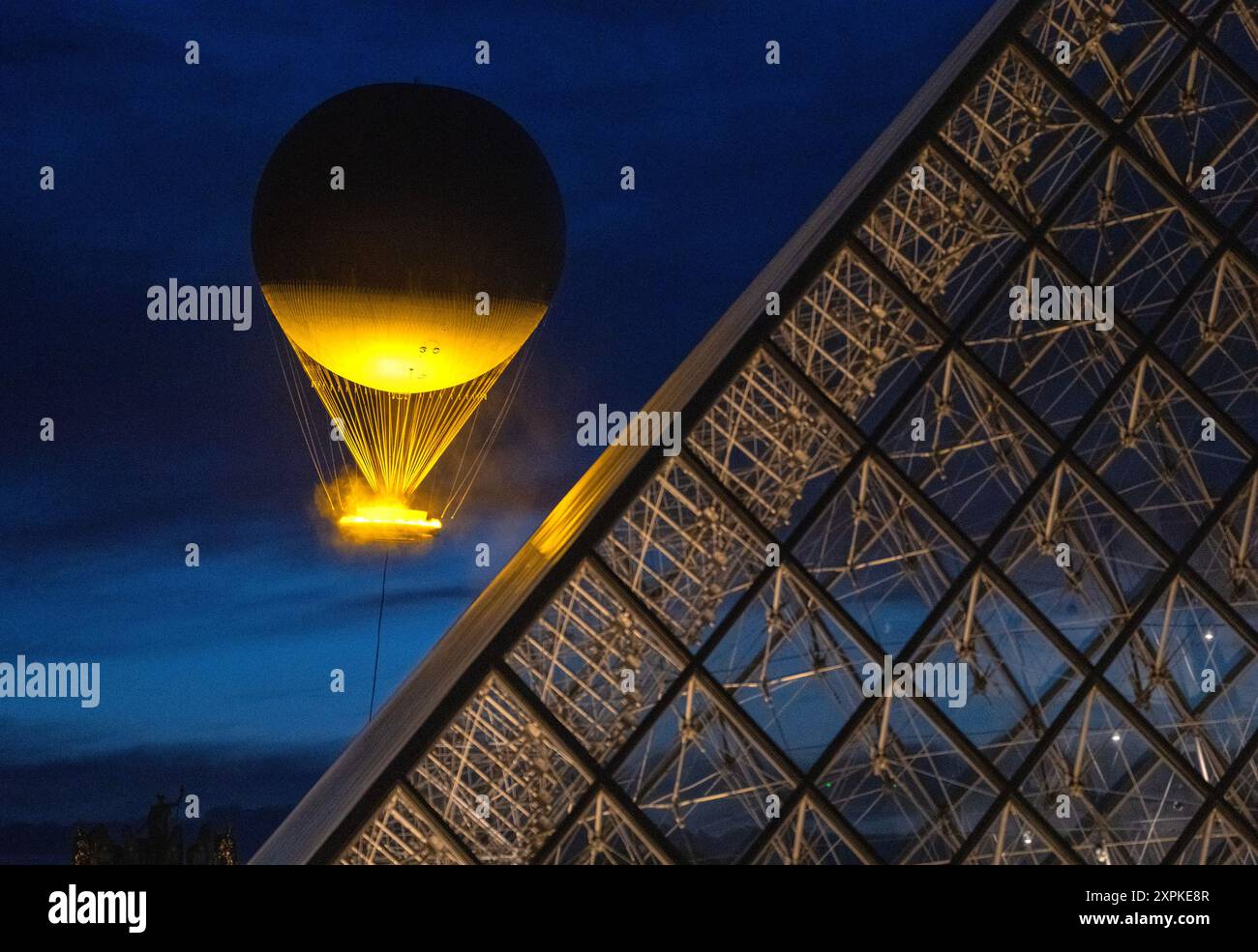 Parigi, Francia. 6 agosto 2024. Il Calderone Olimpico sorge dopo il tramonto vicino alla Piramide del Louvre a Parigi, Francia, martedì 6 agosto 2024. La fiamma elettrica olimpica è alta 100 metri con un anello di fuoco di 22 piedi di diametro e si innalza di 200 piedi nell'aria per alcune ore ogni notte. I Giochi estivi 2024 a Parigi proseguono fino all'11 agosto. Foto di Pat Benic/UPI credito: UPI/Alamy Live News Foto Stock