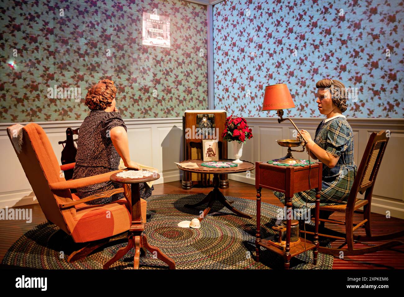 National Museum of the Marine Corps Pearl Harbor Exhibit Triangle Virginia // TRIANGLE, Virginia — la Pearl Harbor Homefront Exhibit presso il National Museum of the Marine Corps ritrae una scena toccante di una madre e una figlia nel loro salotto ascoltando le notizie dell'attacco di Pearl Harbor. Una fotografia del loro figlio e fratello, che è schierato con i Marines, siede in primo piano sul tavolino, catturando il profondo impatto emotivo delle notizie in tempo di guerra sulle famiglie americane durante la seconda guerra mondiale Foto Stock