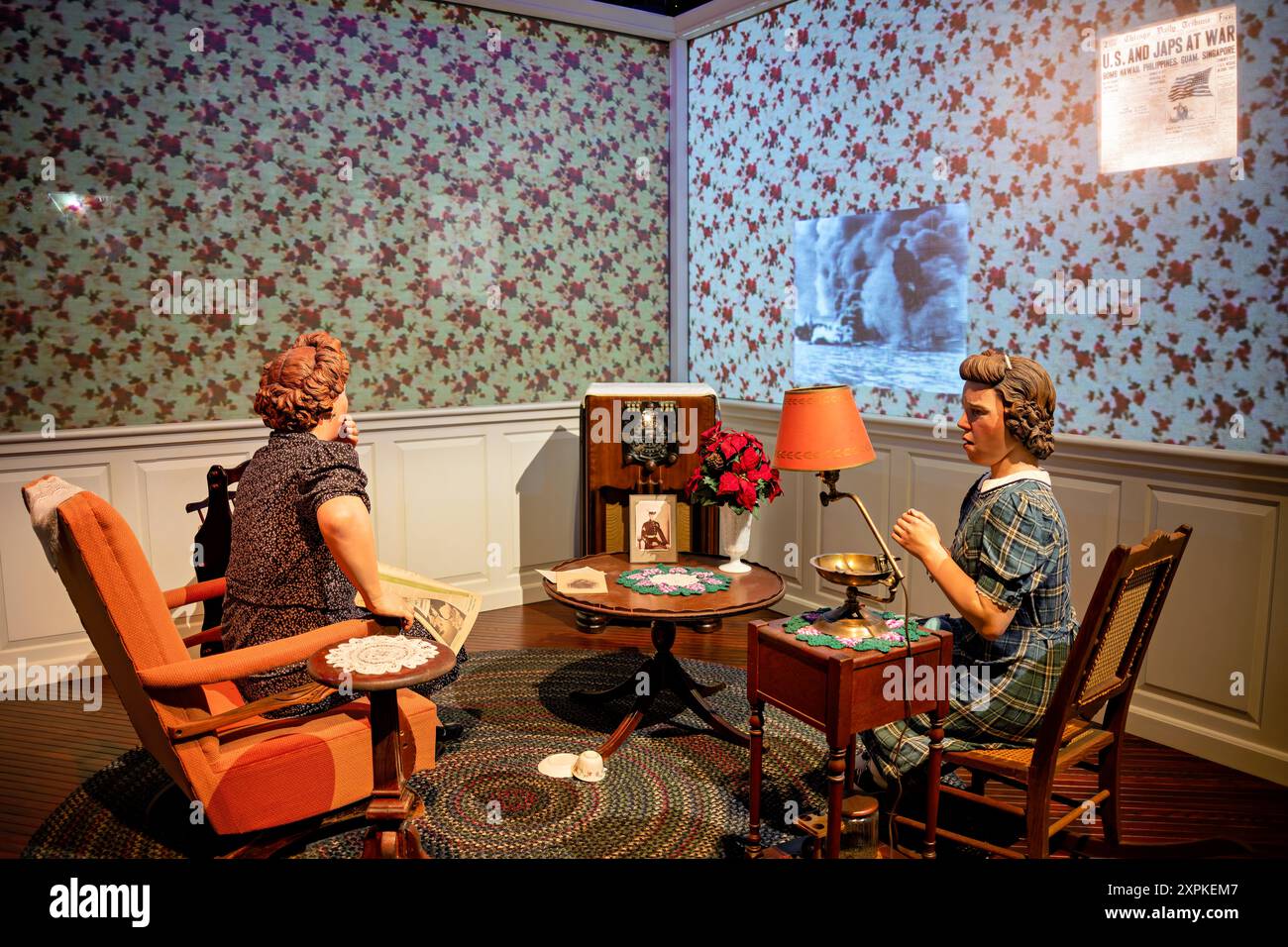National Museum of the Marine Corps Pearl Harbor Exhibit Triangle Virginia // TRIANGLE, Virginia — la Pearl Harbor Homefront Exhibit presso il National Museum of the Marine Corps ritrae una scena toccante di una madre e una figlia nel loro salotto ascoltando le notizie dell'attacco di Pearl Harbor. Una fotografia del loro figlio e fratello, che è schierato con i Marines, siede in primo piano sul tavolino, catturando il profondo impatto emotivo delle notizie in tempo di guerra sulle famiglie americane durante la seconda guerra mondiale Foto Stock