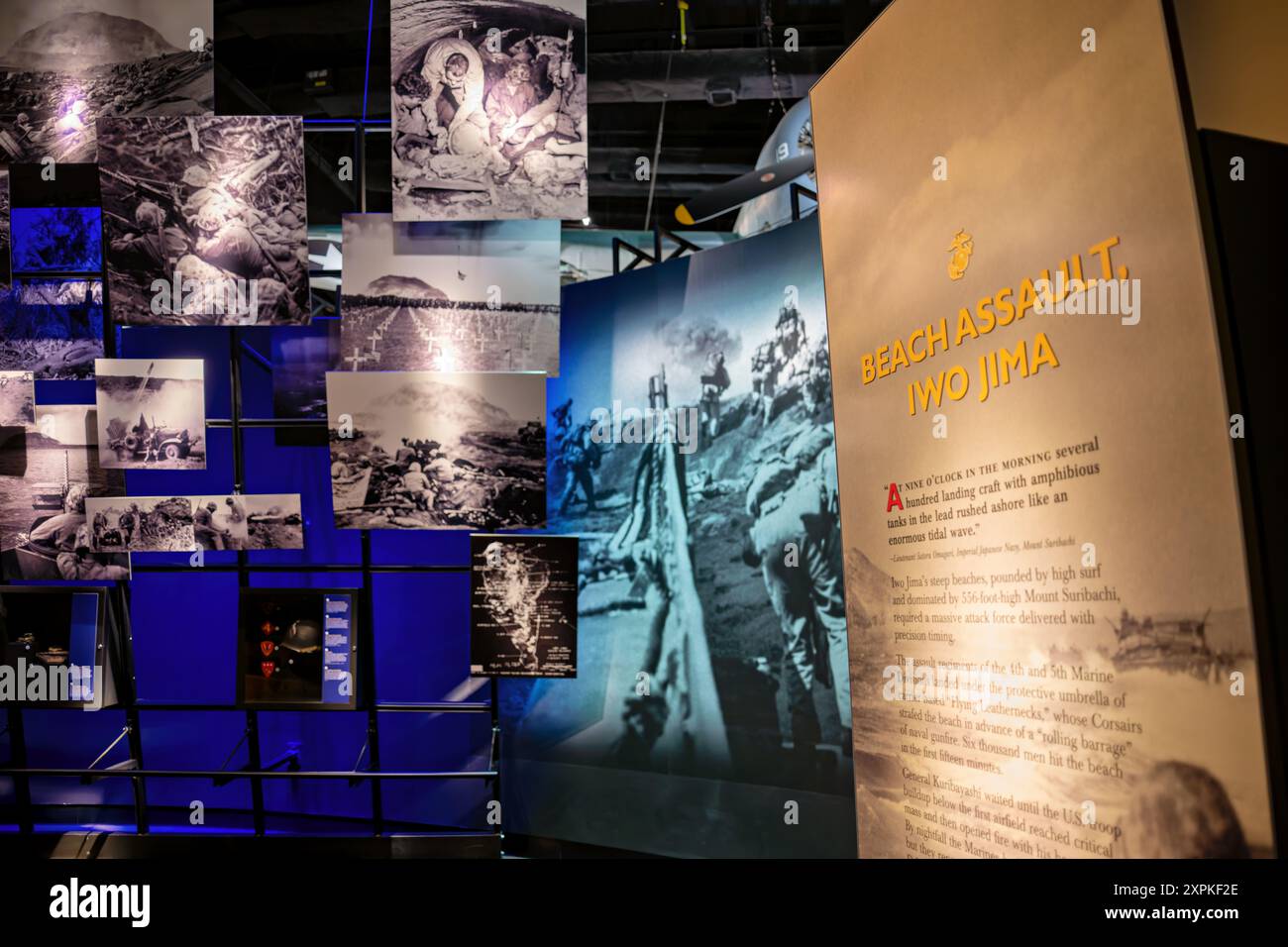 National Museum Of The Marine Corps Iwo Jima Exhibit Triangle Virginia | TRIANGLE, Virginia — Una parete di fotografie d’archivio accanto al pannello "Assalto alla spiaggia, Iwo Jima“ al National Museum of the Marine Corps documenta l’invasione del 1945, dalle imbarcazioni di sbarco che si avvicinano alla riva fino alle conseguenze nel terreno vulcanico dell’isola. La mostra racconta come le divisioni d’assalto dei Marines sono sbarcate sotto la copertura aerea Corsair e i colpi navali contro le difese comandate dal generale Tadamichi Kuribayashi. Foto Stock