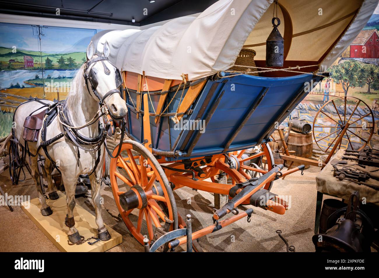 Virginia Freight Wagon Luray Virginia United States // LURAY, Virginia, Stati Uniti — un Virginia Freight Waggon del 1810, costruito a Newtown (ora Stephens City), Virginia, è in mostra al Luray Valley Museum. Questo tipo di carro, tipicamente trainato da una squadra di sei cavalli con campane, era cruciale per il trasporto di merci dalla valle dello Shenandoah a Baltimora, giocando un ruolo vitale nel commercio americano all'inizio del XIX secolo prima dell'avvento dei canali e delle ferrovie. Foto Stock