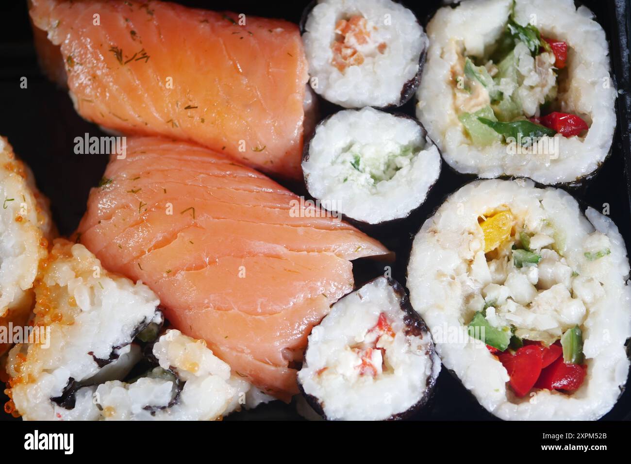 Concediti un delizioso piatto di sushi assortito con salmone fresco e deliziosi involtini Veggie Foto Stock