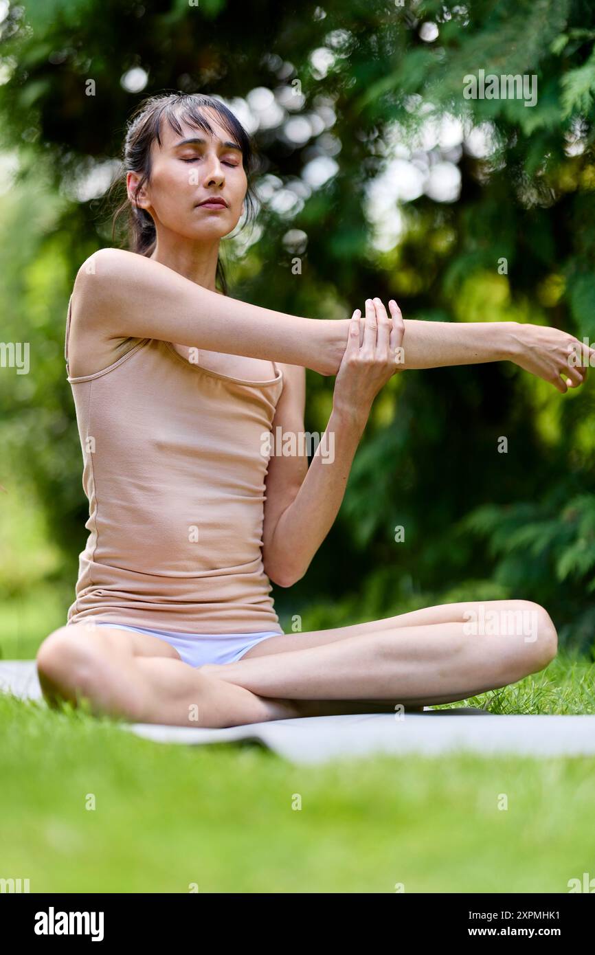 Donna che pratica yoga all'aperto Foto Stock