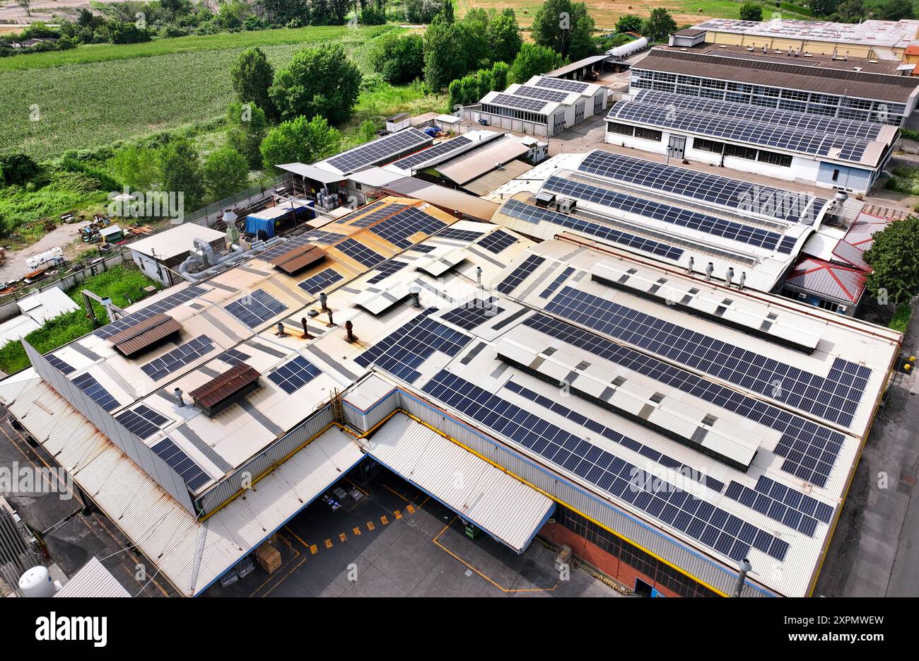 Vista aerea di un vecchio edificio industriale riprogettato con pannelli fotovoltaici per ridurre l'impronta ecologica Foto Stock