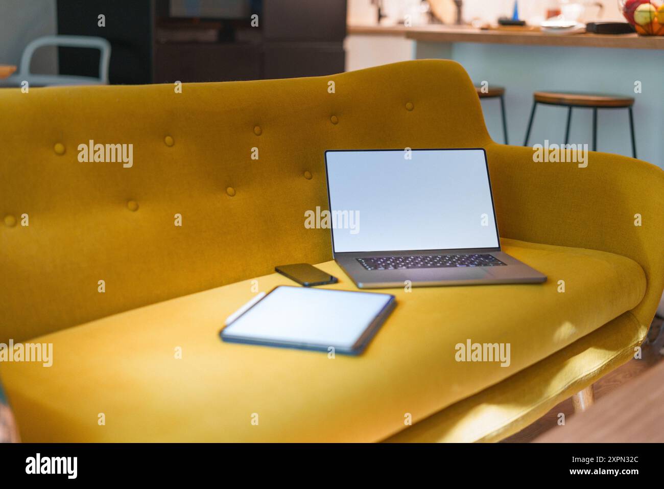 Comodo divano con laptop e tablet grafico. Pulire il modello di schermo bianco vuoto. Interni di casa. Foto Stock