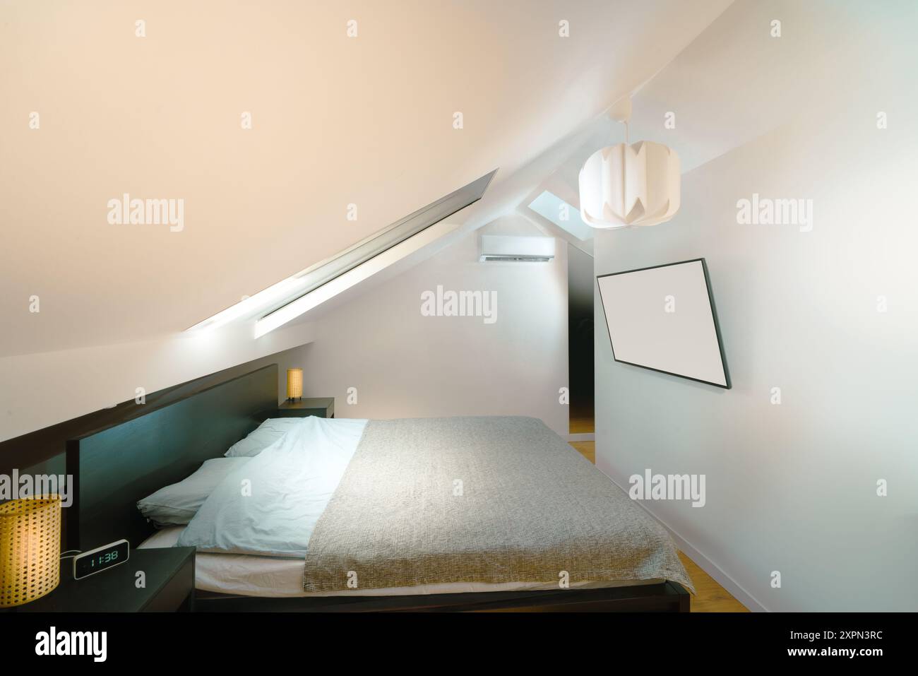 Attico della camera. Camera da letto con orologio intelligente e display lcd a parete. Impostazioni dell'aria condizionata. Foto Stock