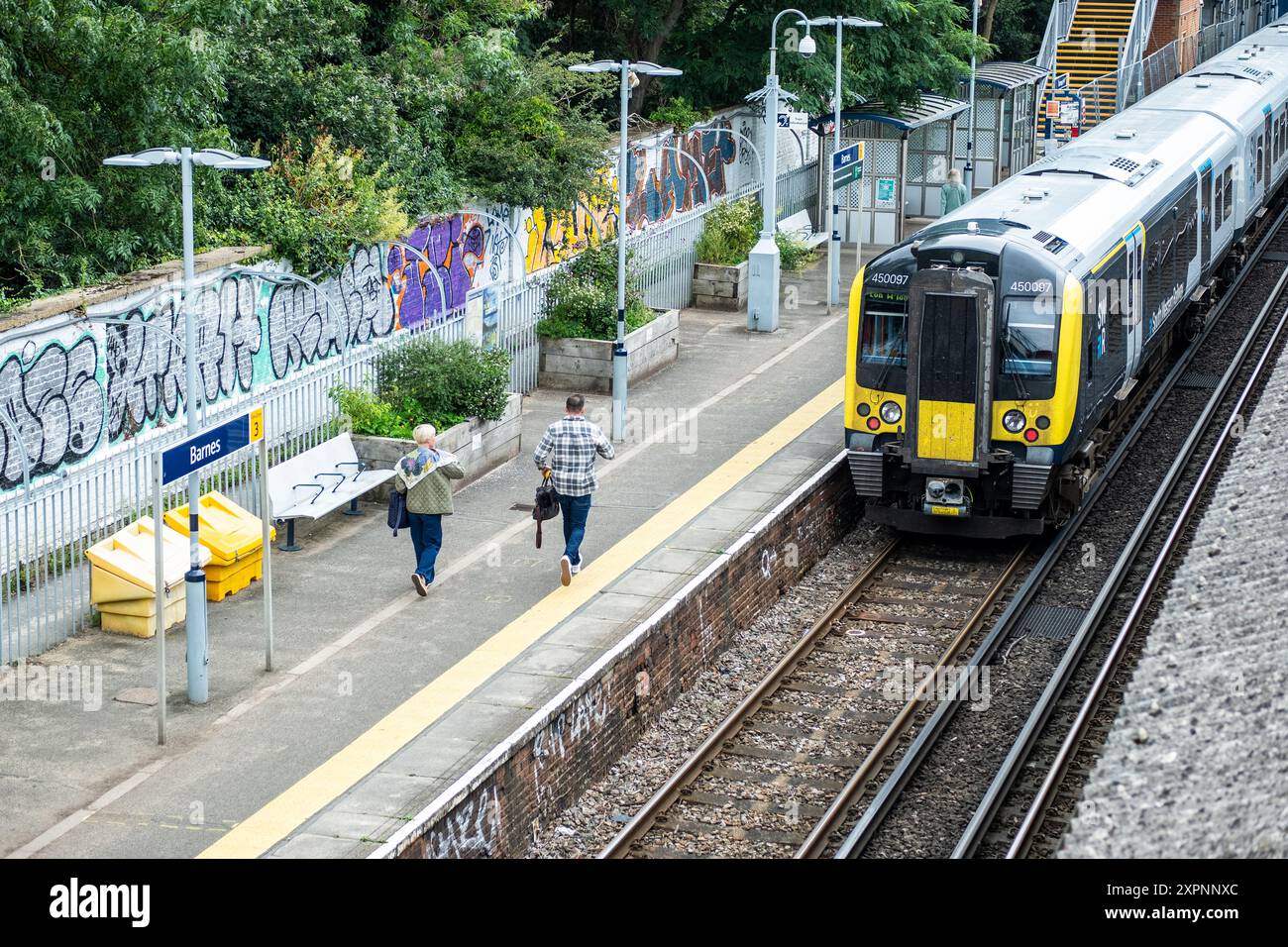 LONDRA - LUGLIO 2024: Passeggeri ferroviari che viaggiano sulla banchina di un treno sud-occidentale alla stazione di Barnes nel sud-ovest di Londra Foto Stock