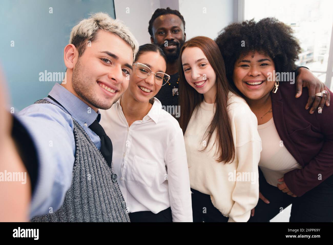 Selfie foto ritratto di un team aziendale multietnico e multirazziale che si trova in ufficio dopo il lavoro, prospettiva della fotocamera del telefono cellulare, piccolo gruppo di persone Foto Stock