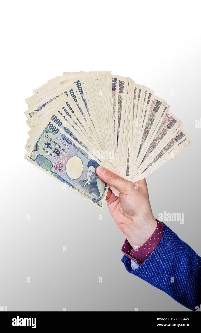 Banconote giapponesi in mano su sfondo isolato. Giappone yen (JPY) crash econmy e concetto di crisi dei mercati finanziari. Foto Stock