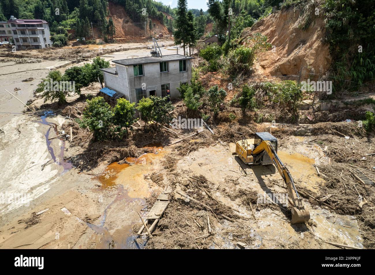 Changsha. 7 agosto 2024. Una foto aerea scattata il 7 agosto 2024 mostra i soccorritori in caso di disastri che liberano il fango vicino a una casa nella città di Zhoumensi di Zixing City, nella provincia di Hunan della Cina centrale. Le comunicazioni e gli alimentatori sono in gran parte ripresi a Zixing, una città a livello di contea nella provincia di Hunan. I temporali hanno devastato Hunan dalla fine di luglio, innescando inondazioni e frane che hanno distrutto case e strade interrotte. Crediti: Chen Sihan/Xinhua/Alamy Live News Foto Stock