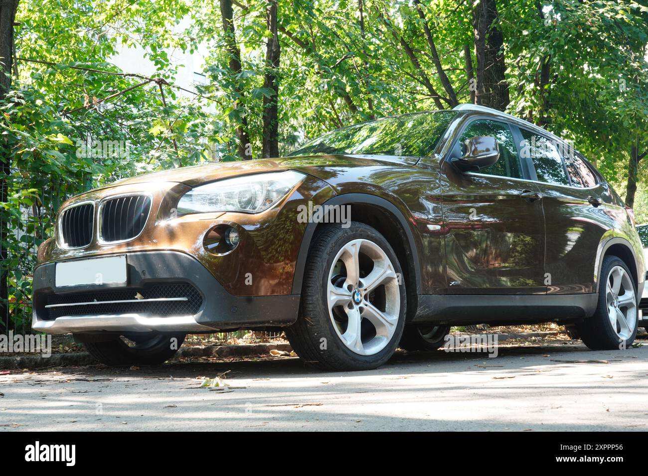 Bucarest, Romania - 21 luglio 2024: Vista frontale della BMW X5 SUV marrone parcheggiata vicino agli alberi Foto Stock