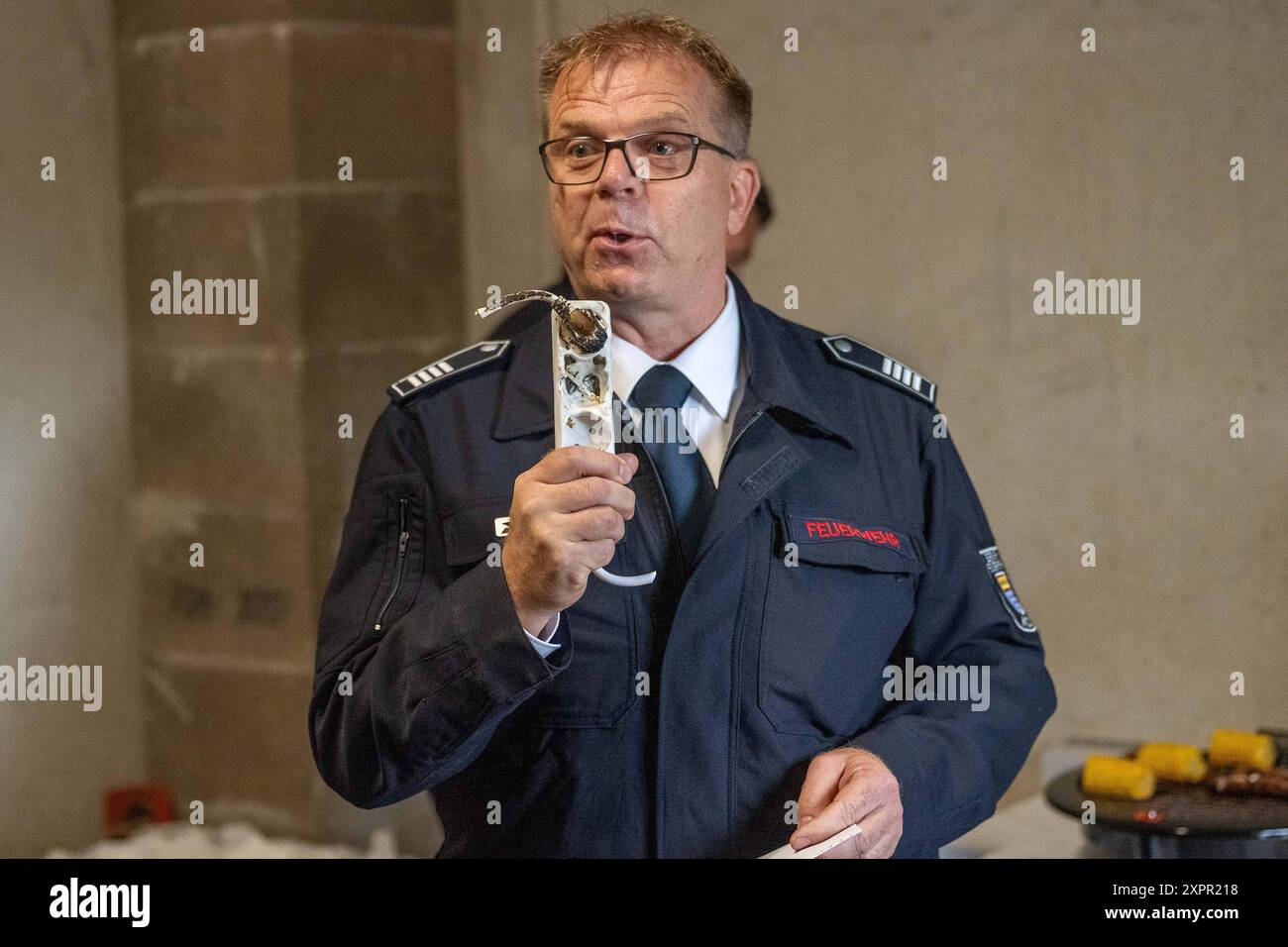 Pressetermin der Koelner Berufsfeuerwehr ueber die Gefahren beim Grillen 07.08.24 07.08.2024, Freizeit, Ungluecke: Pressetermin der Koelner Berufsfeuerwehr, Demonstration der Gefahren beim Grillen im Fuehrungs- und Schulungszentrum a Koeln. Ulrich Laschet Berufsfeuerwehr Koeln, Brandamtsrat zeigt eine der haeufigsten Brandursachen bei Verwendung eines Elektrogrills. Foto: Kirchner-Media/TH *** Rassegna stampa dei vigili del fuoco professionali di Colonia sui pericoli del barbecue 07 08 24 07 08 2024, tempo libero, incidenti evento stampa dei vigili del fuoco professionali di Colonia, dimostrazione del Foto Stock