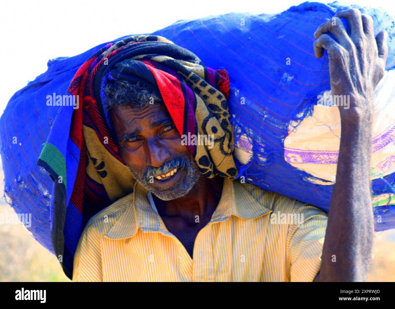 Ritratto di un contadino durante una dura giornata di lavoro in un villaggio rurale. Javadhu Hills, Tamil Nadu. India. Foto Stock