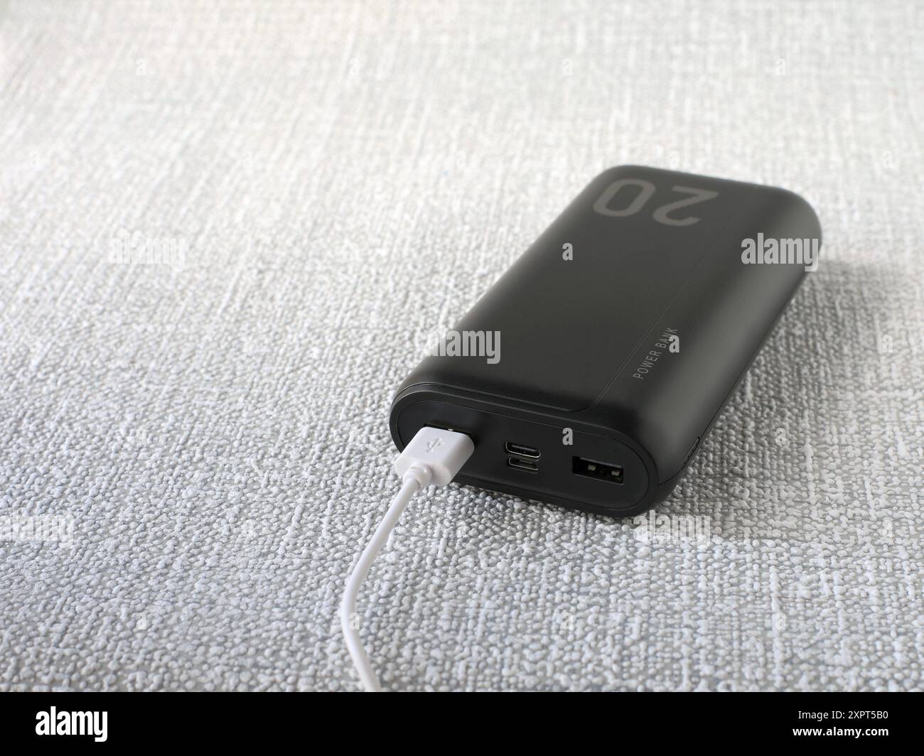 Immagine di un potente power Bank portatile con una capacità di 20.000 milliampere con un cavo collegato. Foto Stock