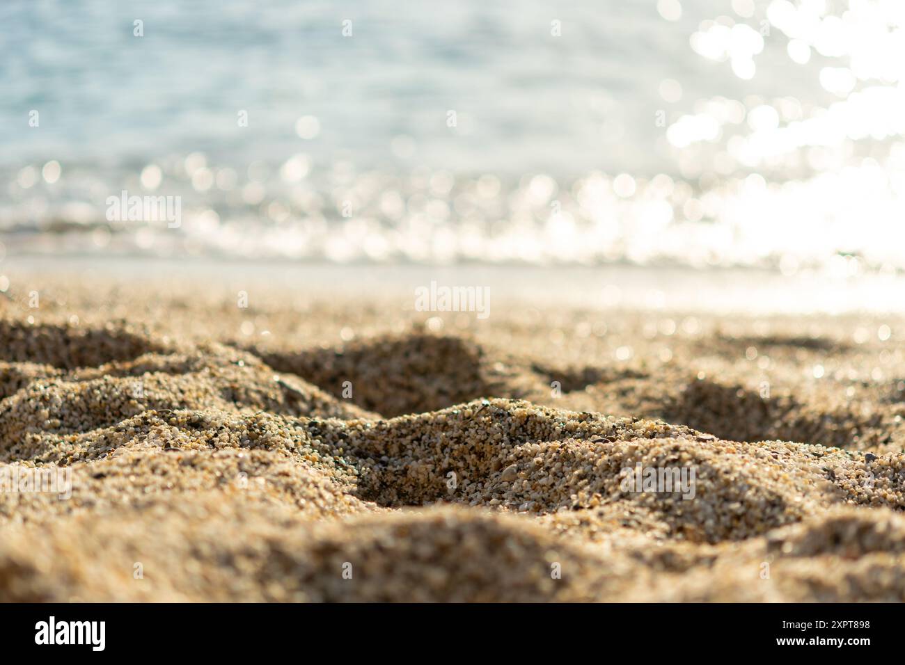 Spiaggia sabbiosa con sfondo blu del mare. Concetto estivo. Messa a fuoco selettiva. Foto Stock