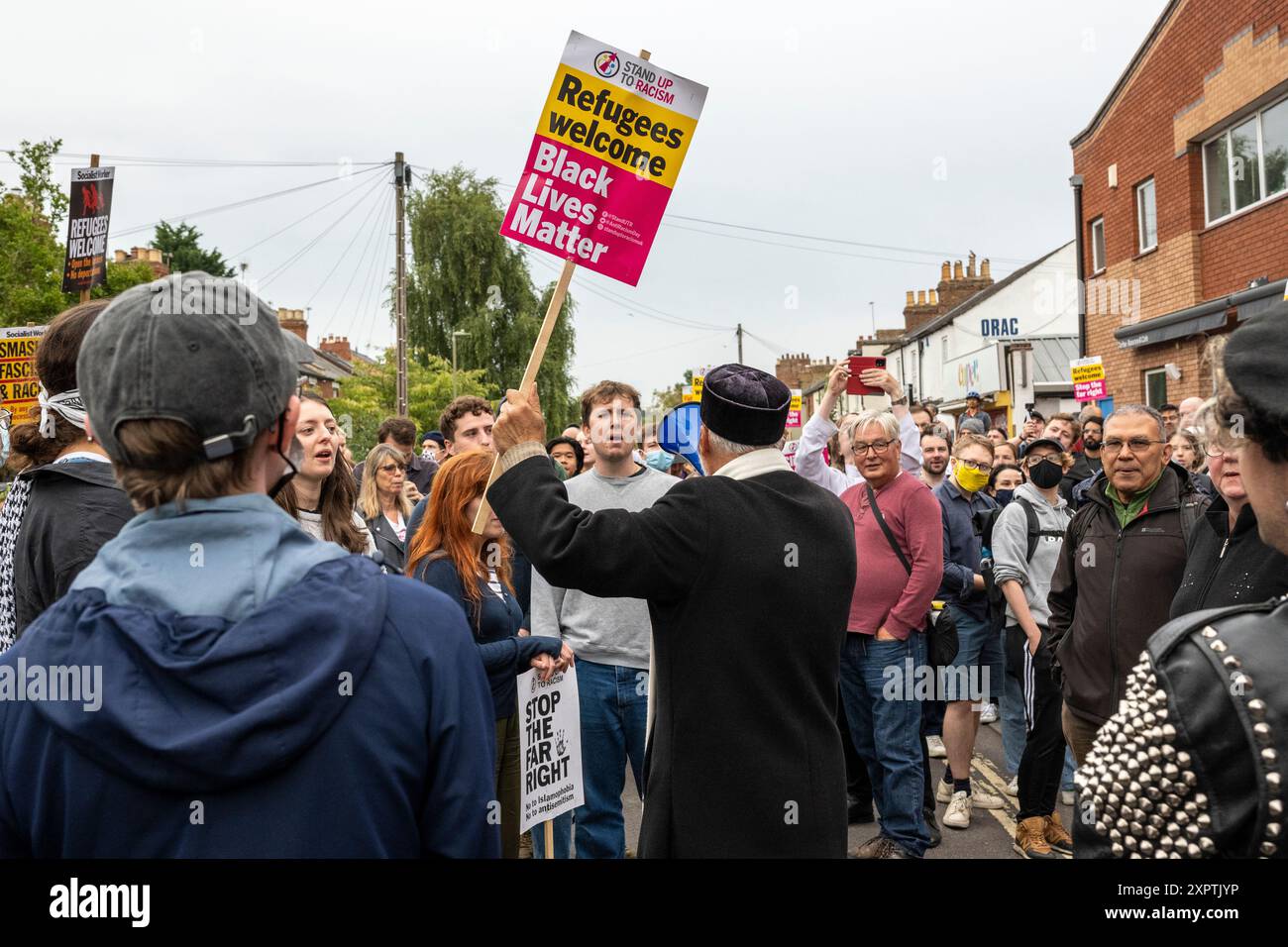 Centinaia di manifestanti anti-razzisti hanno costituito uno scudo protettivo fuori dal centro di accoglienza per l'asilo sulla Magdalen Road a est di Oxford, portando cartelli, cantando e cantando a sostegno di rifugiati e immigrati di fronte alle voci di un'azione di estrema destra di mercoledì sera. Foto Stock