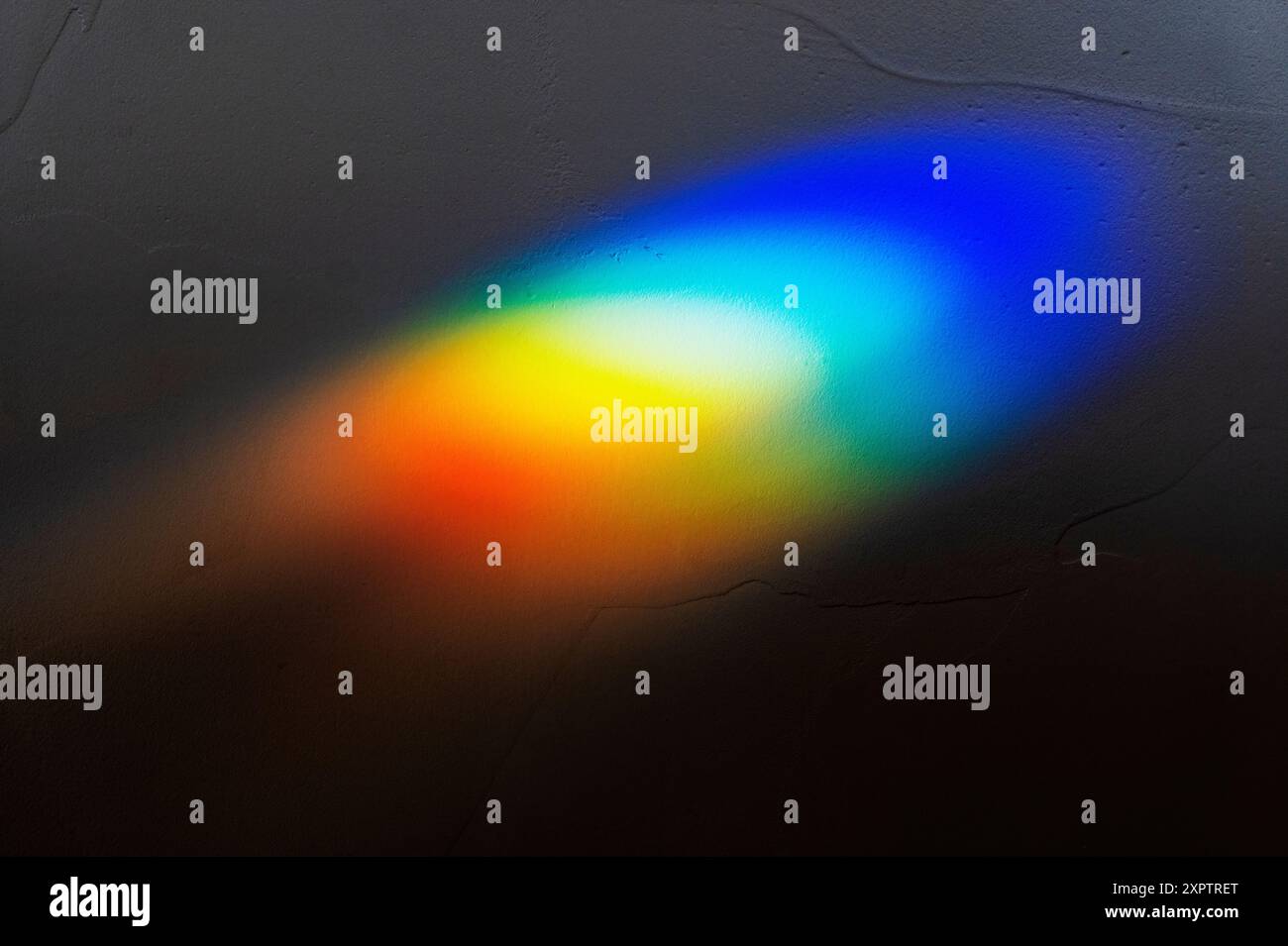 La luce solare rifrangente attraverso la vetrata crea un prisma di colori arcobaleno Foto Stock