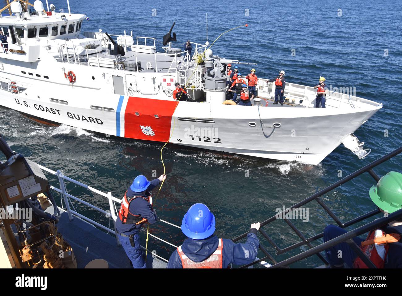Sottufficiale di seconda classe Warren Gardner, compagno di un swain a bordo della U.S. Coast Guard Cutter Kimball (WMSL 765), lancia una linea da Kimball a USCGC Bailey Barco (WPC-1122) durante la prima evoluzione a est del rifornimento in mare (AFAS) tra un cutter per la sicurezza nazionale e un cutter a risposta rapida nel Mare di Bering, il 2 luglio 2024. L'AFAS estese la resistenza della Bailey Barco e portò l'equipaggio della Bailey Barco a condurre oltre 10 imbarchi a Bristol Bay, Alaska, un'area non regolarmente accessibile dalla FRCS a causa di vincoli logistici. Foto della Guardia Costiera degli Stati Uniti di Cadet Madison Whitw Foto Stock