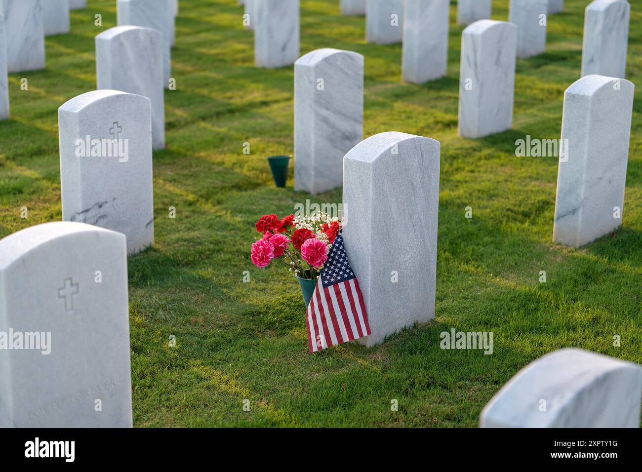 Cimitero nazionale di Sarasota dell'esercito americano con file di lapidi bianche con bandiere e fiori degli Stati Uniti. Concetto Memorial Day Foto Stock