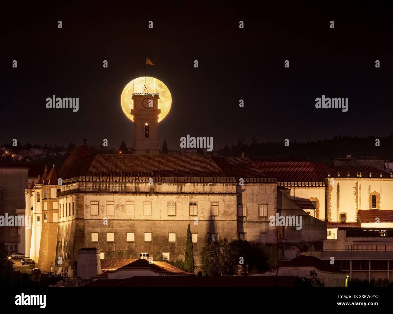 super luna dietro la torre dell'Università di Coimbra in Portogallo. Alba di notte. Foto Stock