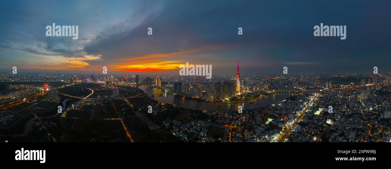 Una vista aerea della città di ho chi Minh al tramonto, un cielo vivace e colorato, il grattacielo Landmark 81 illuminato, il fiume Saigon riflesso nelle luci della città Foto Stock