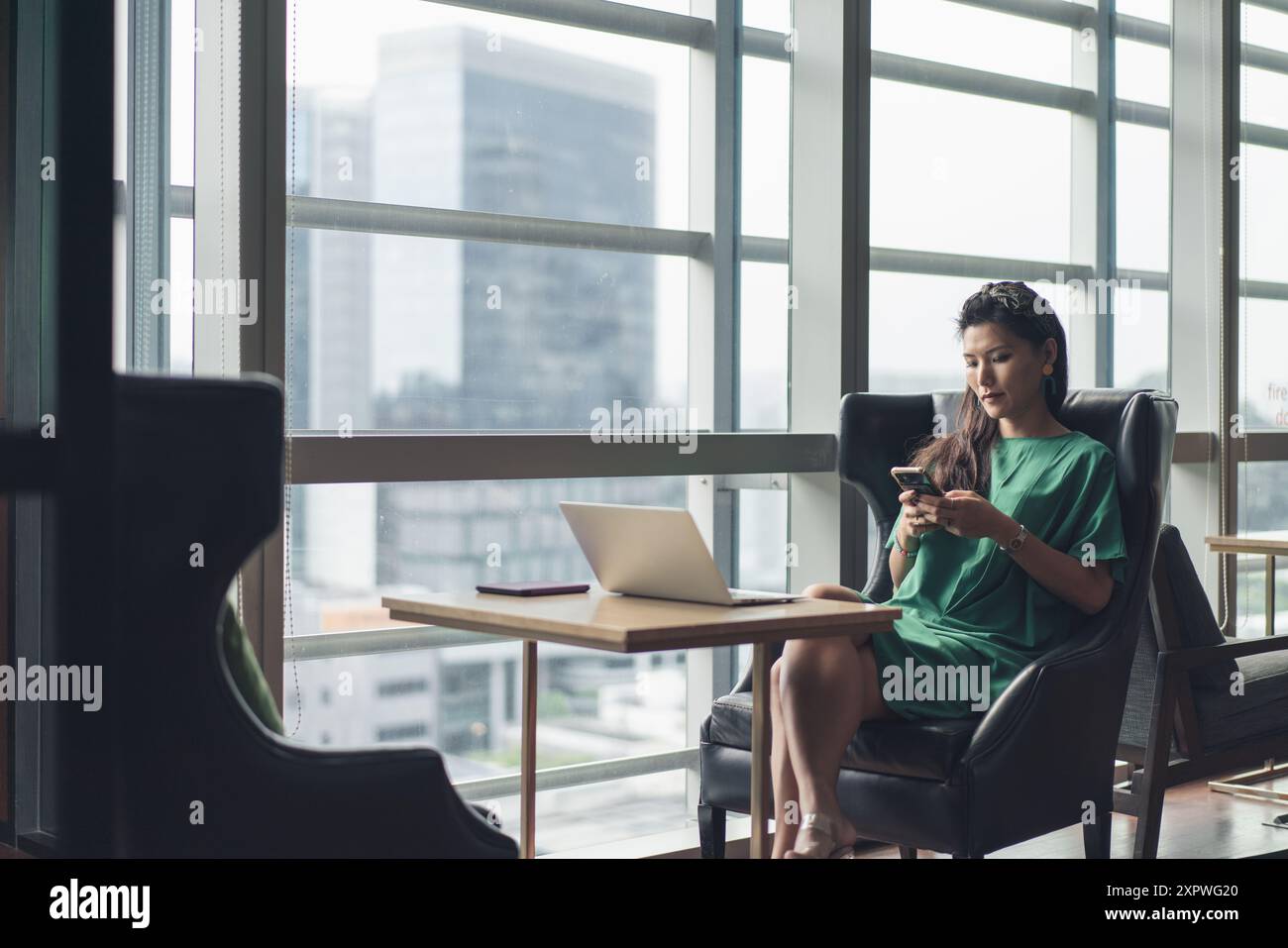 Donna d'affari asiatica hot desking e occupata con il lavoro Foto Stock