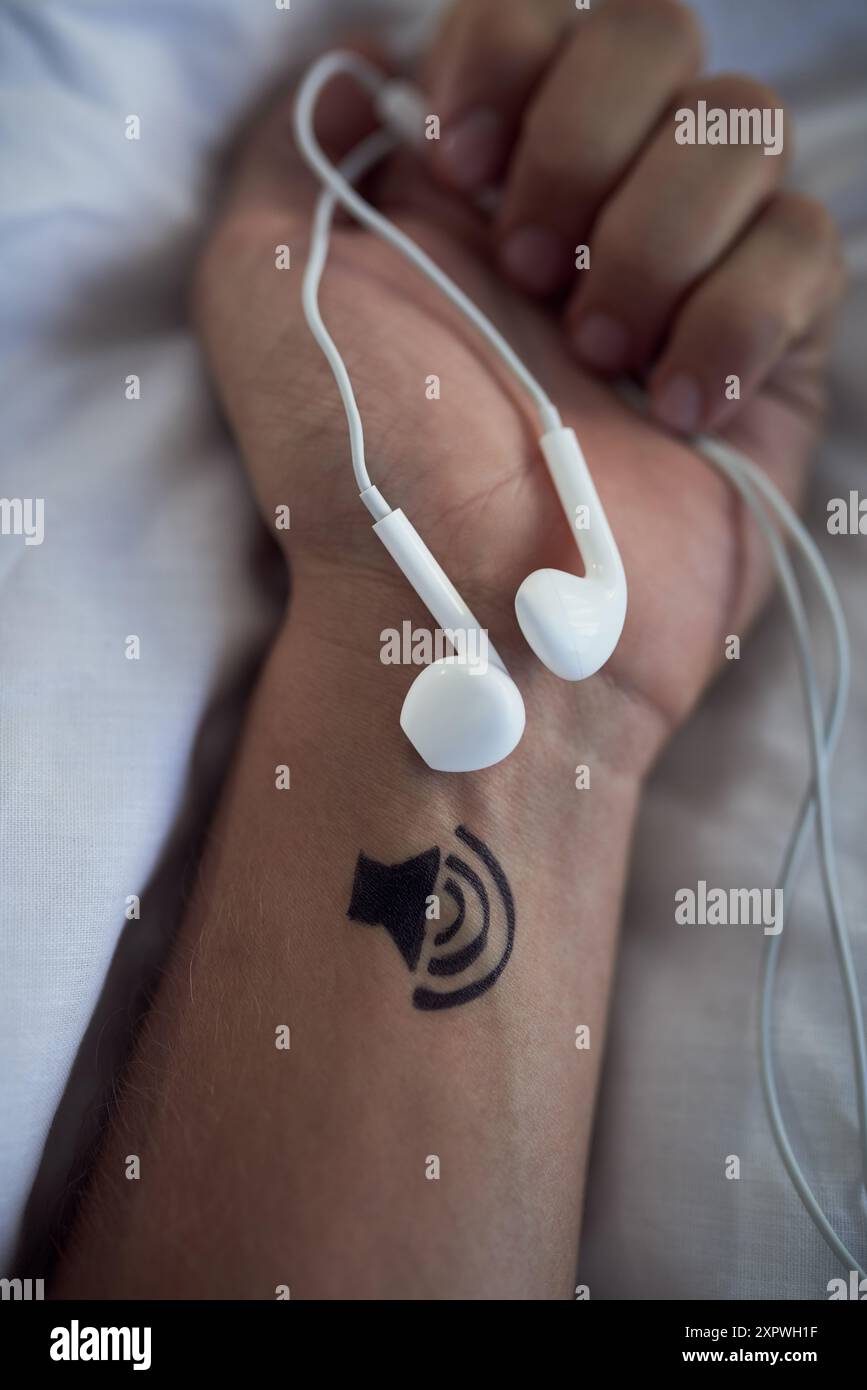 Braccio, persona e auricolari in mano per ascoltare musica o volume per guarire mente, anima e corpo in pausa e rilassarsi. Letto, pista e servizio di streaming per l'autoassistenza Foto Stock