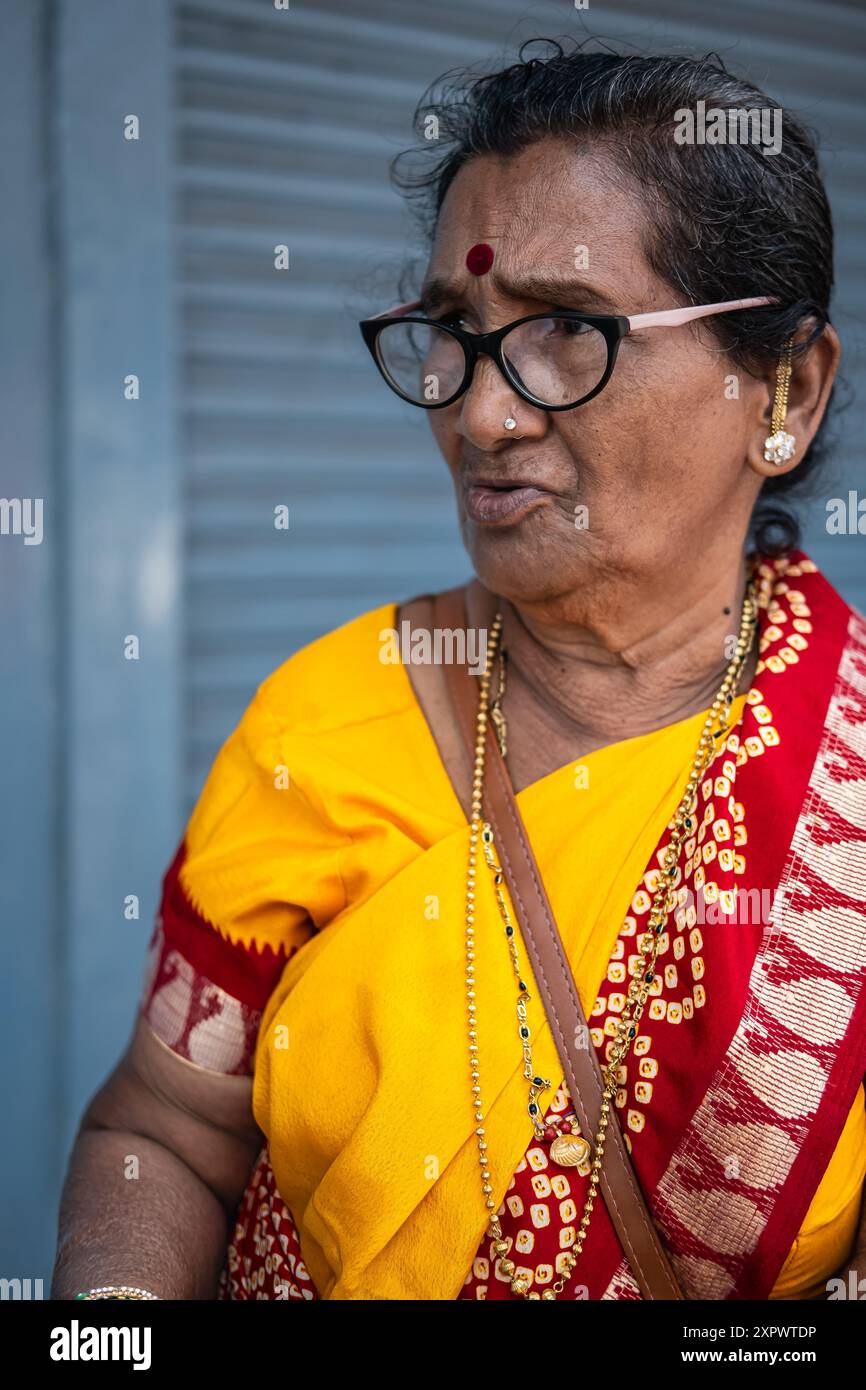 Old Aged Lady indiana che indossa Saree gialle. Asia meridionale induista religiosa anziana donna in abito tradizionale sari. Foto di strada, foto di viaggio-Goa India-J. Foto Stock