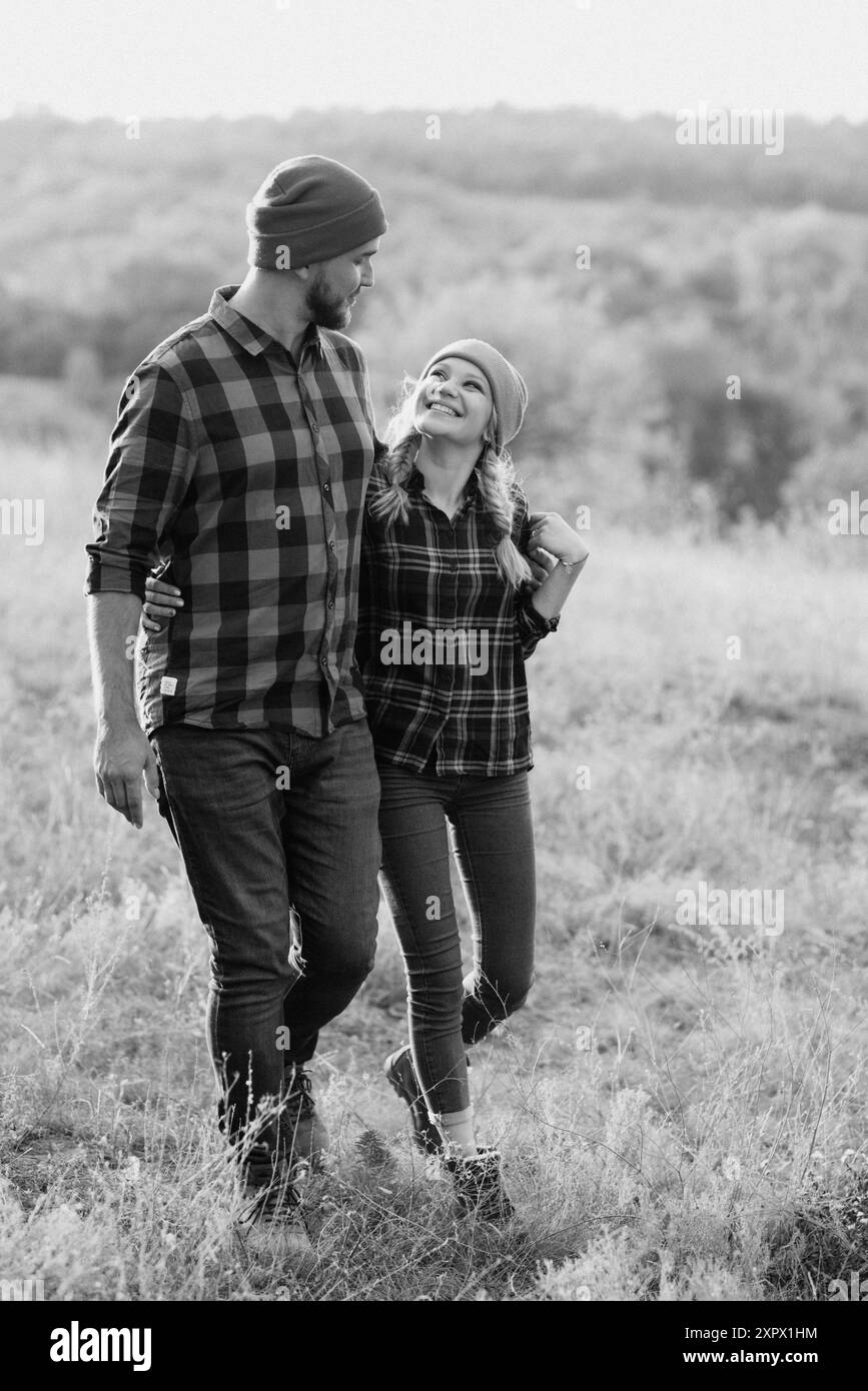 Ragazzo allegro e ragazza su una passeggiata in maglia brillante cappelli e camicie plaid Foto Stock