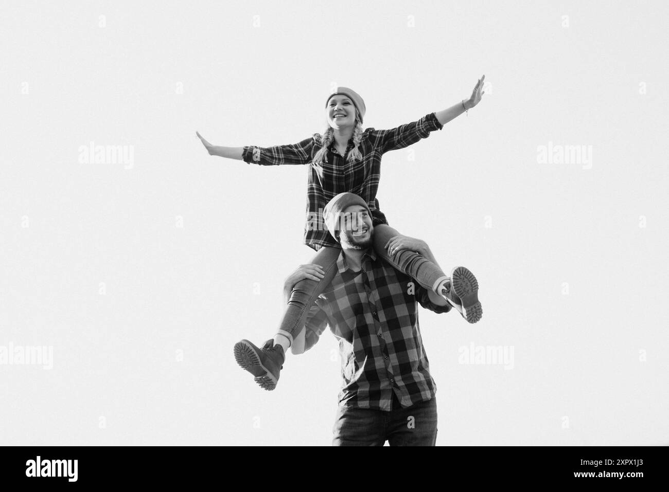 Ragazzo allegro e ragazza su una passeggiata in maglia brillante cappelli e camicie plaid Foto Stock