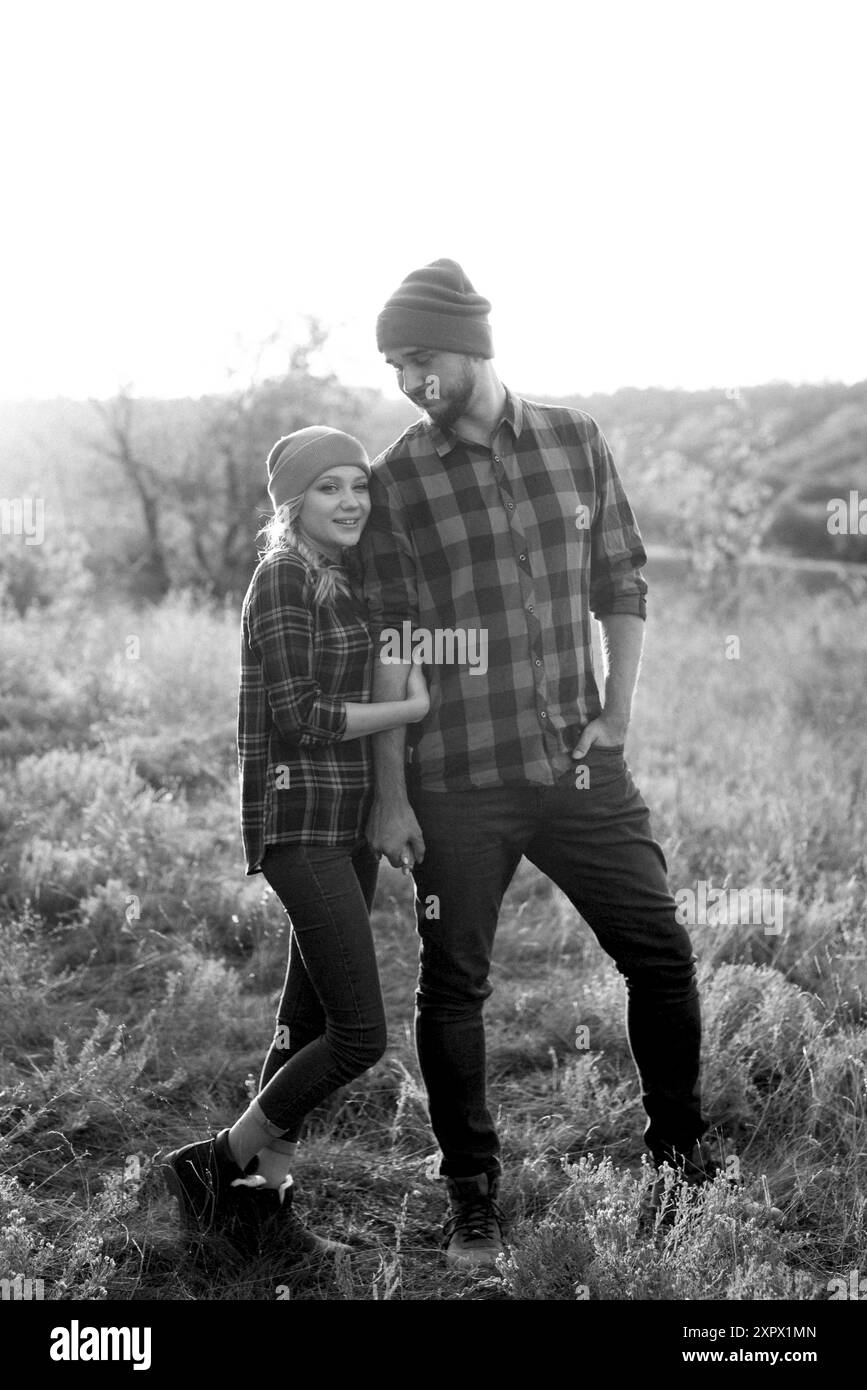 Ragazzo allegro e ragazza su una passeggiata in maglia brillante cappelli e camicie plaid Foto Stock